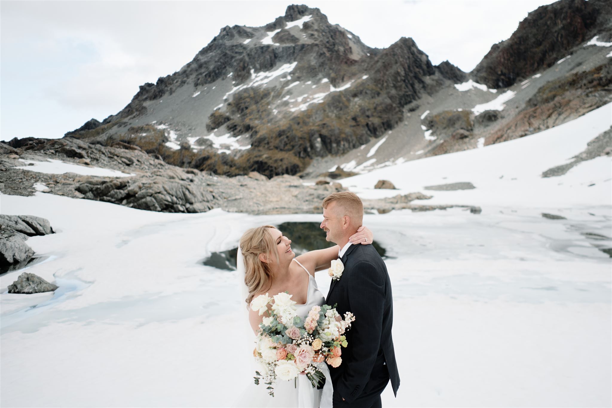 A bride and groom elopement package with a stunning snow covered mountain backdrop.