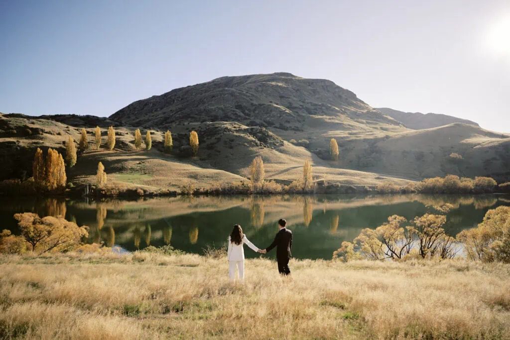 Ayaka Morita's portfolio featuring a bride and groom standing in front of a lake.