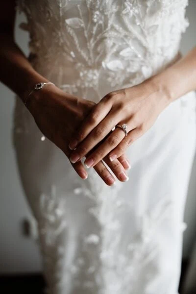 Ayaka Morita's portfolio showcases a bride elegantly adorned in a white wedding dress, clutching her precious wedding rings.