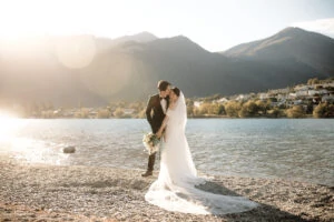 Tracy and Markus' romantic kiss on the shore of Lake Wanaka during their Cecil Peak Heli Wedding.