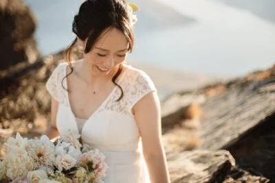 Ayaka Morita's portfolio showcases a bride holding a bouquet on top of a mountain.