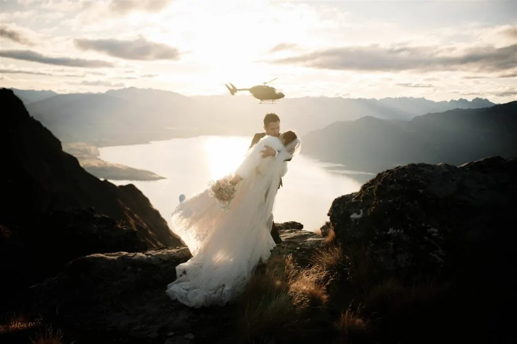 A breathtaking heli-wedding at Cecil Peak in Queenstown, NZ with a stunning mountain backdrop and a helicopter.