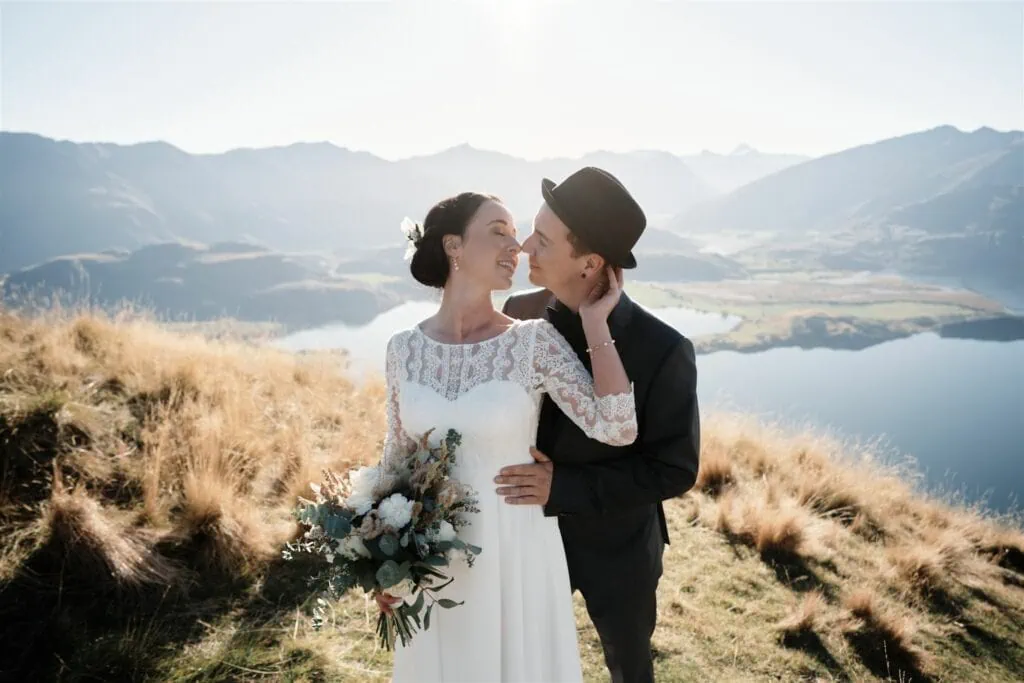 Bride and groom kissing on Coromandel Peak overlooking Lake Wanaka.