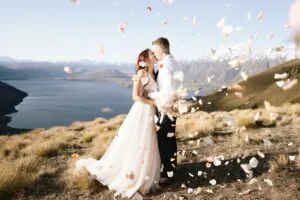 Queenstown New Zealand Elopement Wedding Photographer - Josh Yates captures a breathtaking wedding moment, as a bride and groom share a romantic kiss atop a picturesque New Zealand mountain.