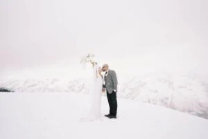 Queenstown New Zealand Elopement Wedding Photographer - A bride and groom atop a snow-covered mountain, showcased in Josh Yates' portfolio.
