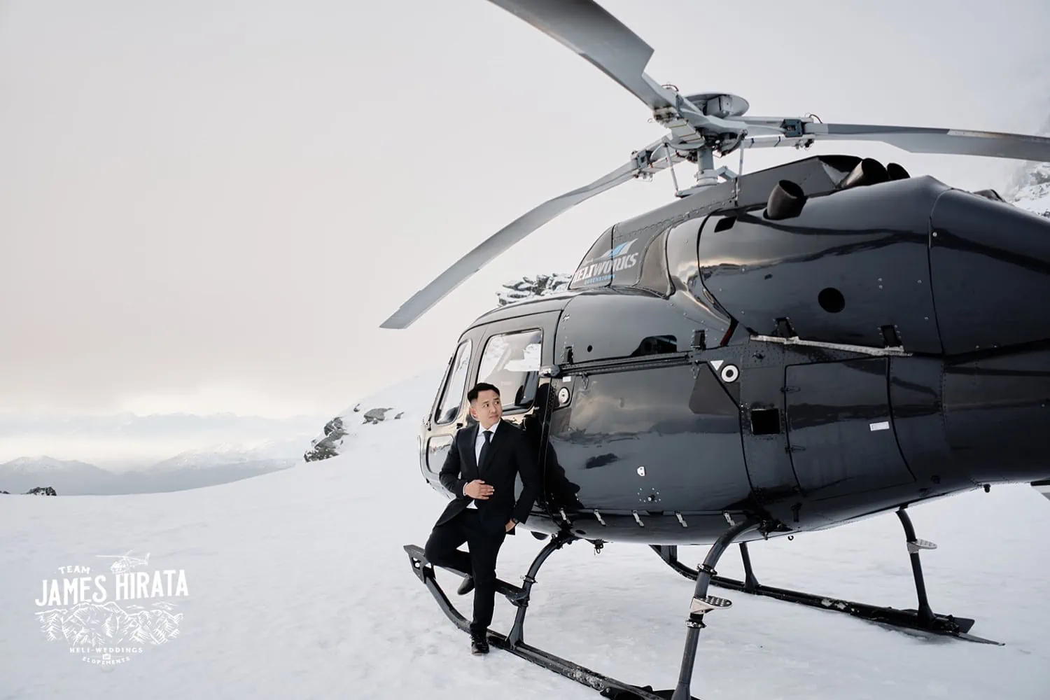A man in a suit posing in Queenstown for a helicopter pre-wedding shoot.