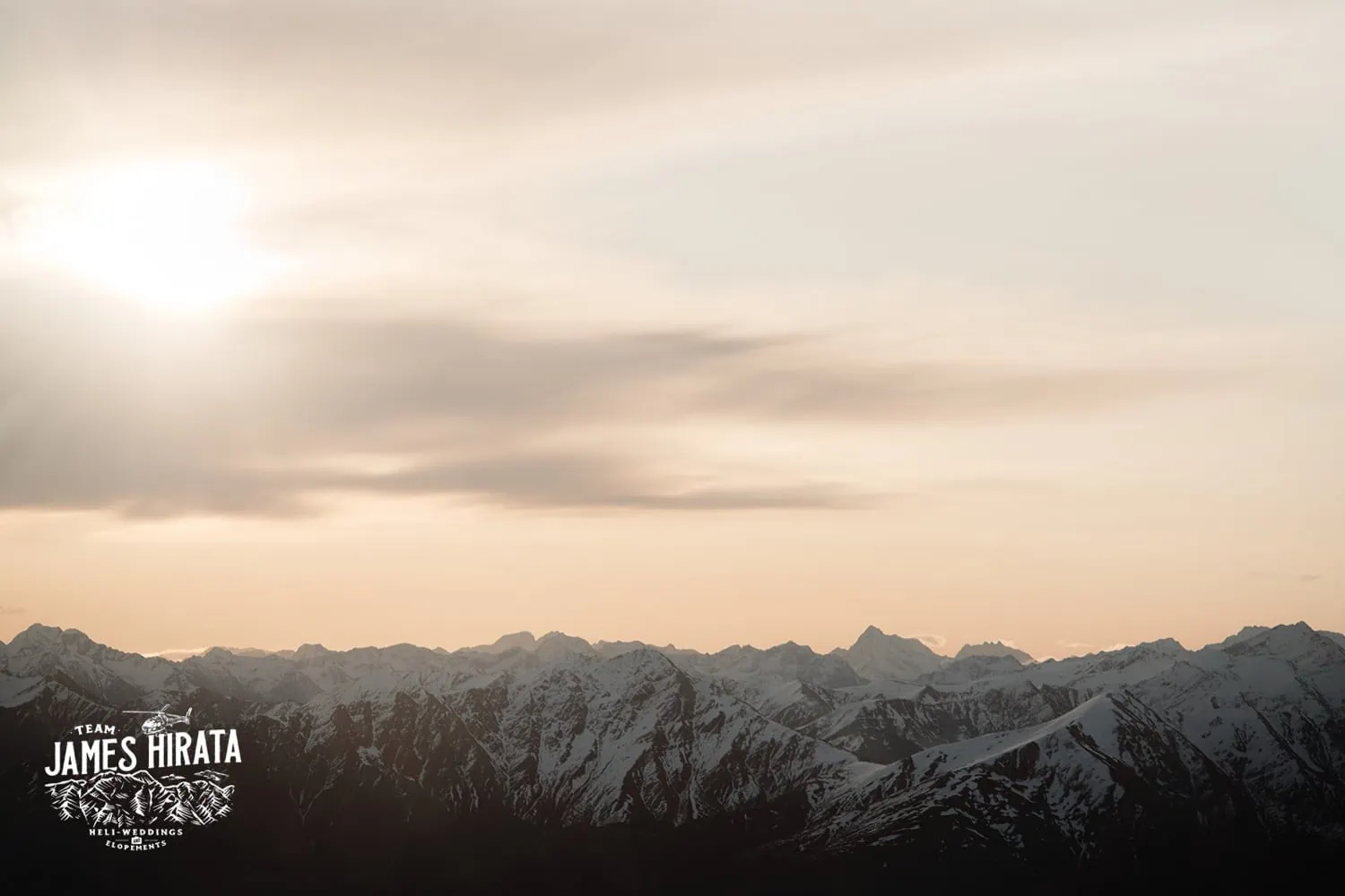 Joan and Brandon's Queenstown Heli Elopement captures the sun setting over snow capped mountains.