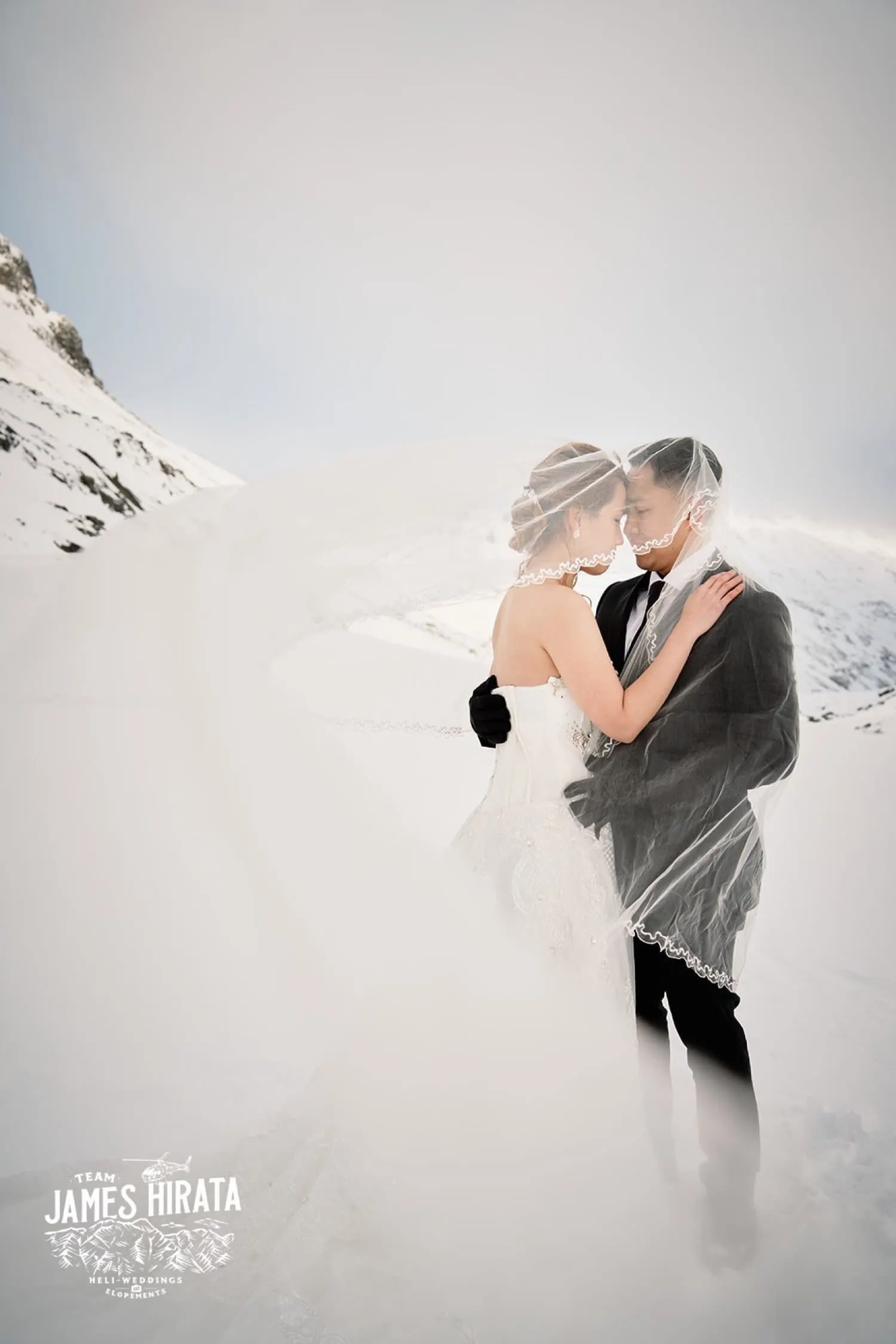 Joan & Brandon embrace in a snowy Queenstown Heli Pre Wedding Shoot.