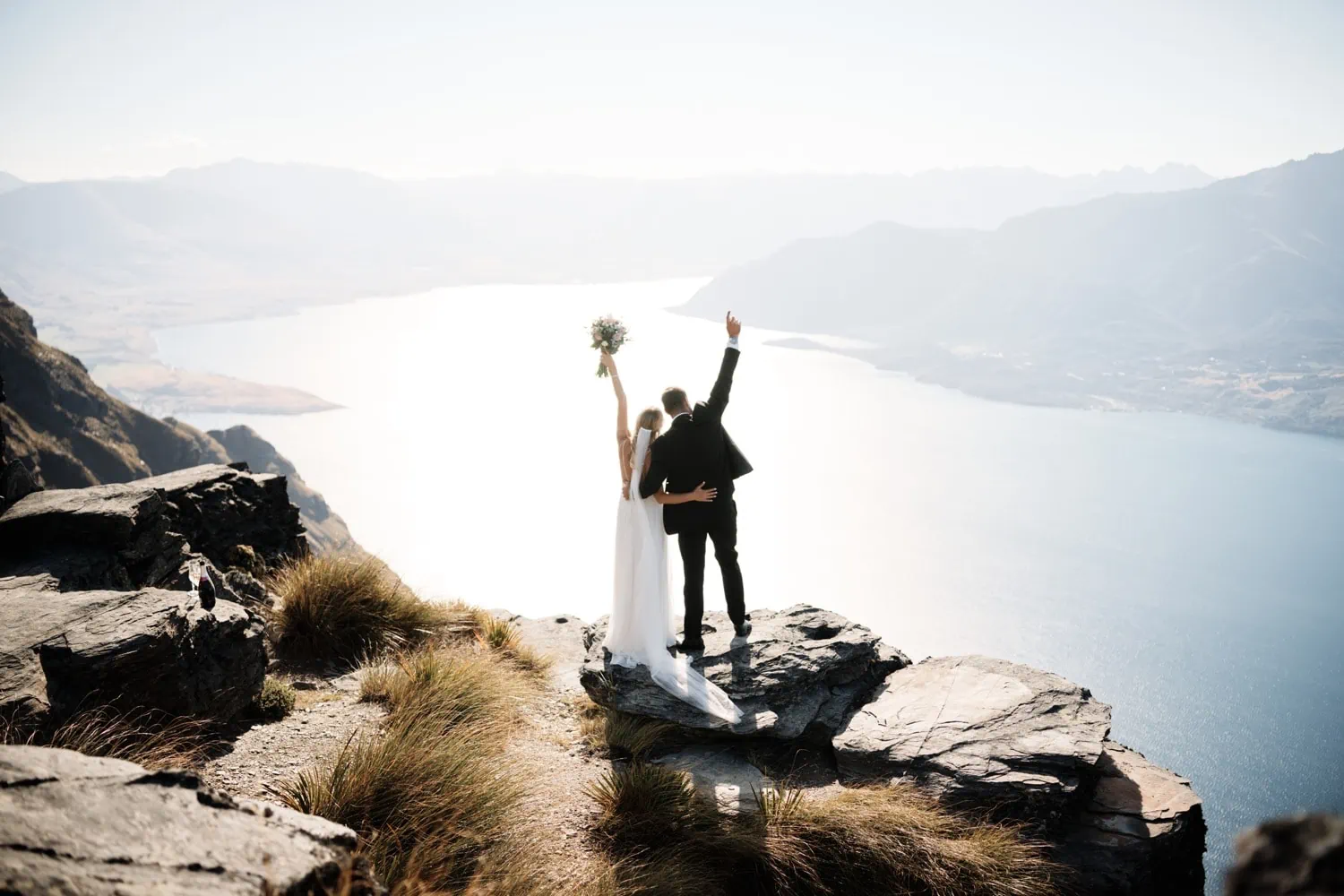 Maggie and Darren's wedding party, standing on top of a mountain overlooking Lake Wanaka.