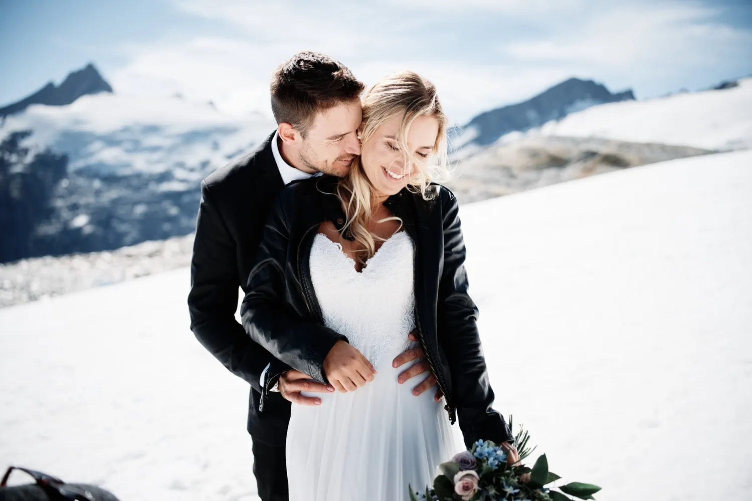 Maggie and Darren's embrace in the snow atop a mountain.