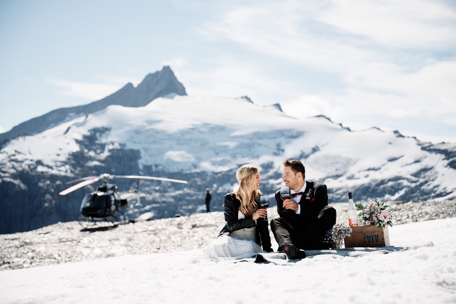 Maggie and Darren's winter wedding photo with a helicopter backdrop.