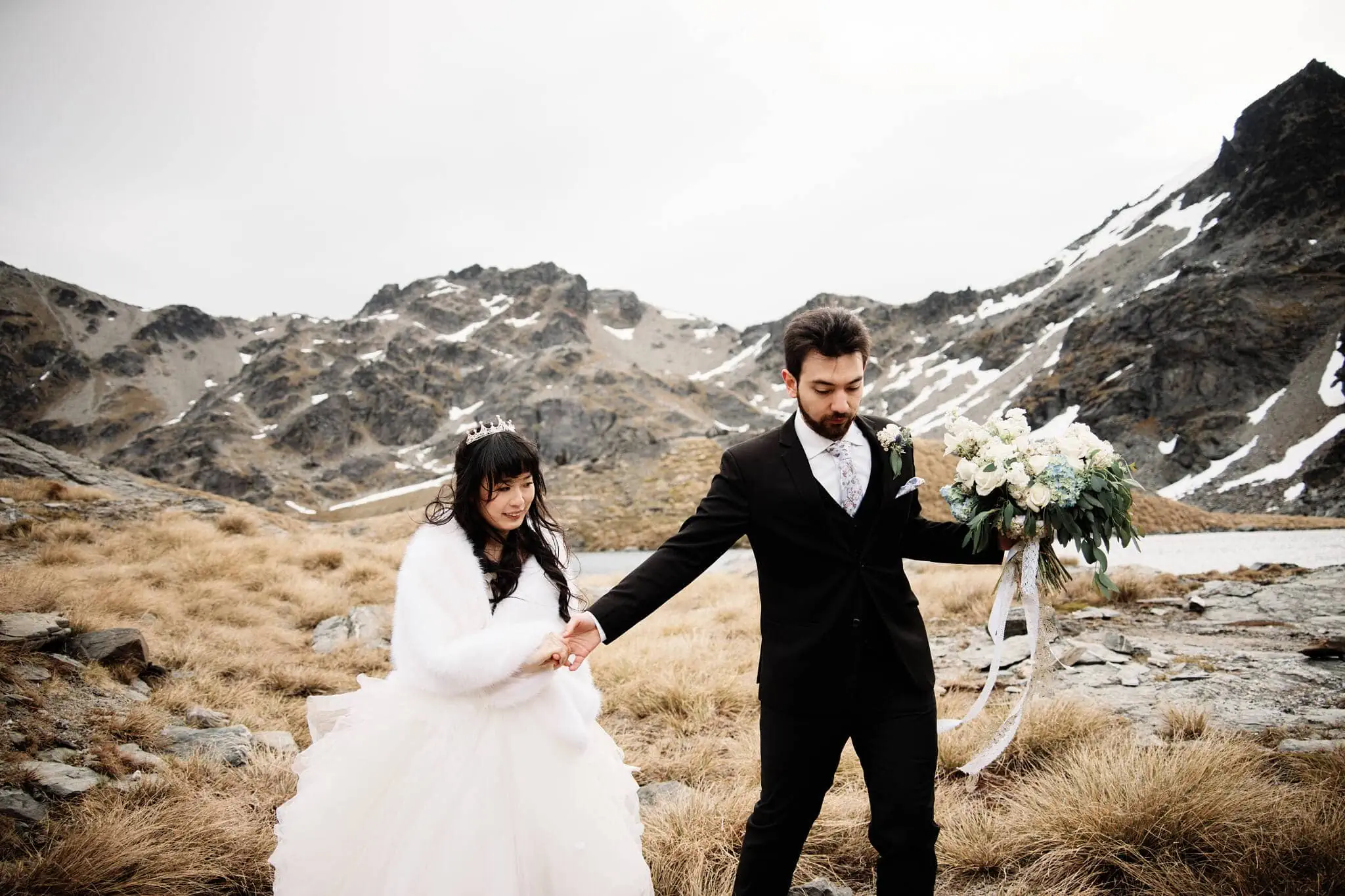 Carlos and Wanzhu have an intimate elopement wedding, holding hands in the mountains at Cecil Peak.