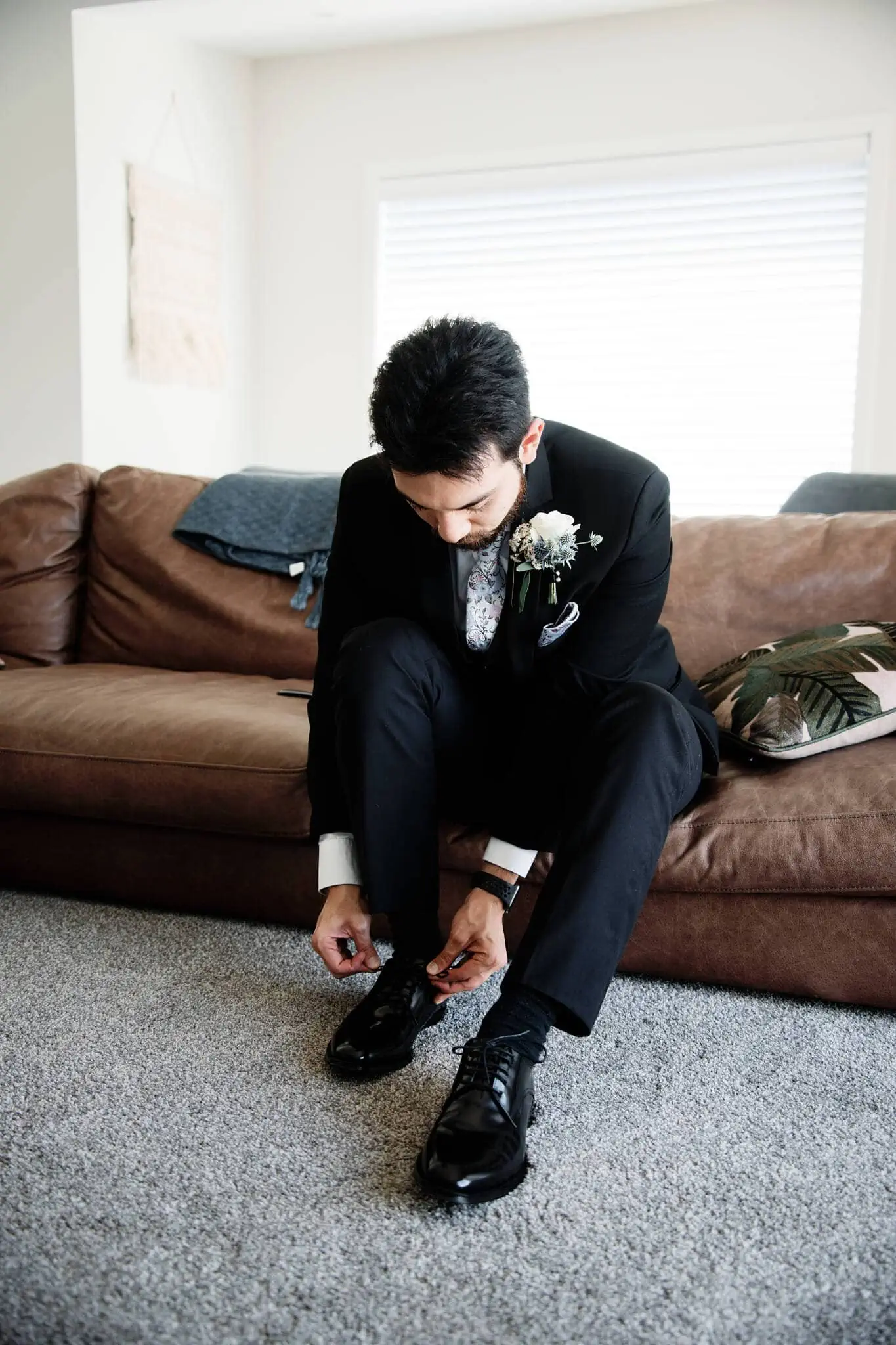 Carlos tying his shoes before his intimate Cecil Peak Heli Elopement Wedding.