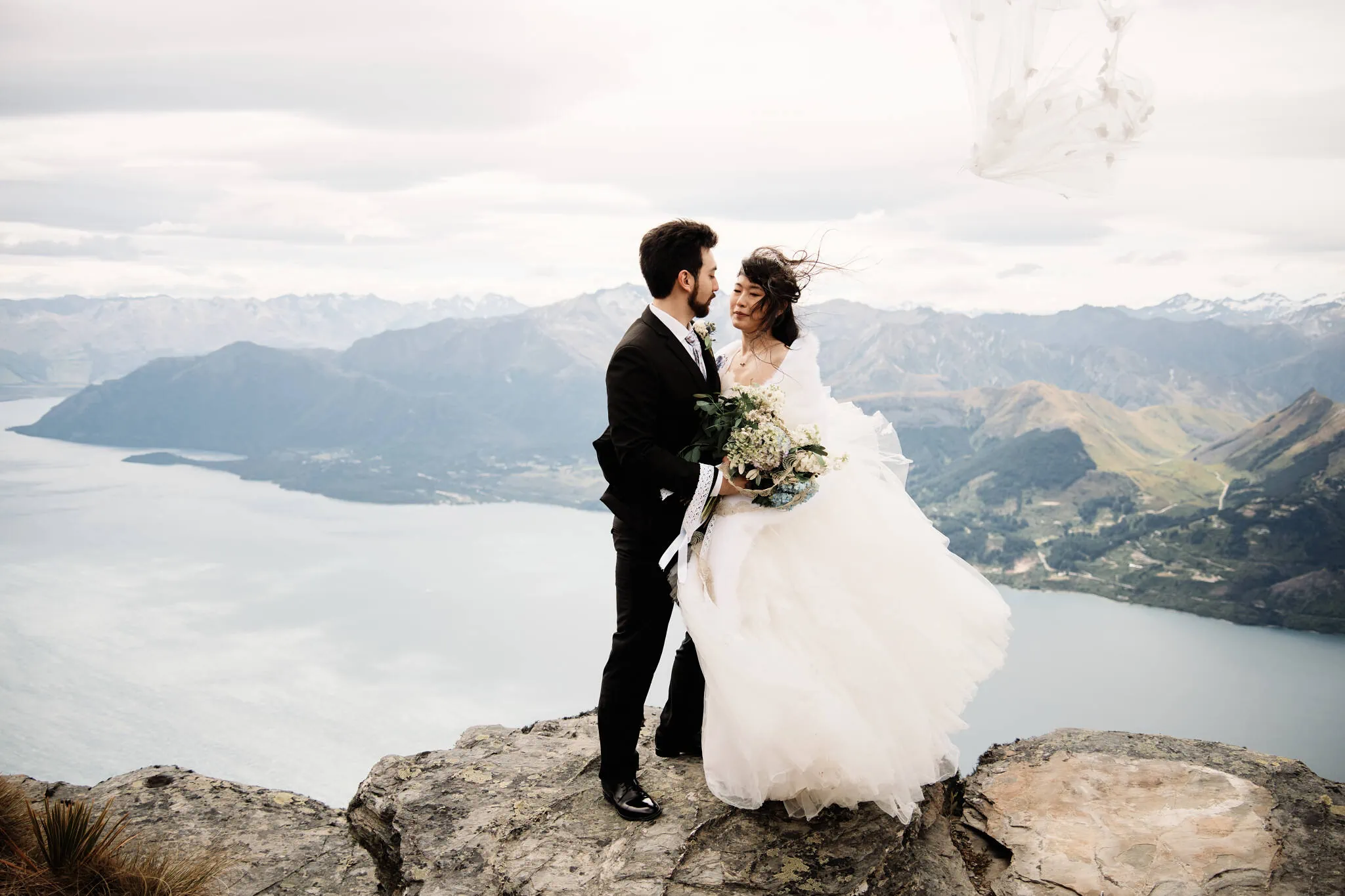 Carlos and Wanzhu's intimate heli elopement wedding on top of Cecil Peak, overlooking Lake Wanaka, with a kiss.