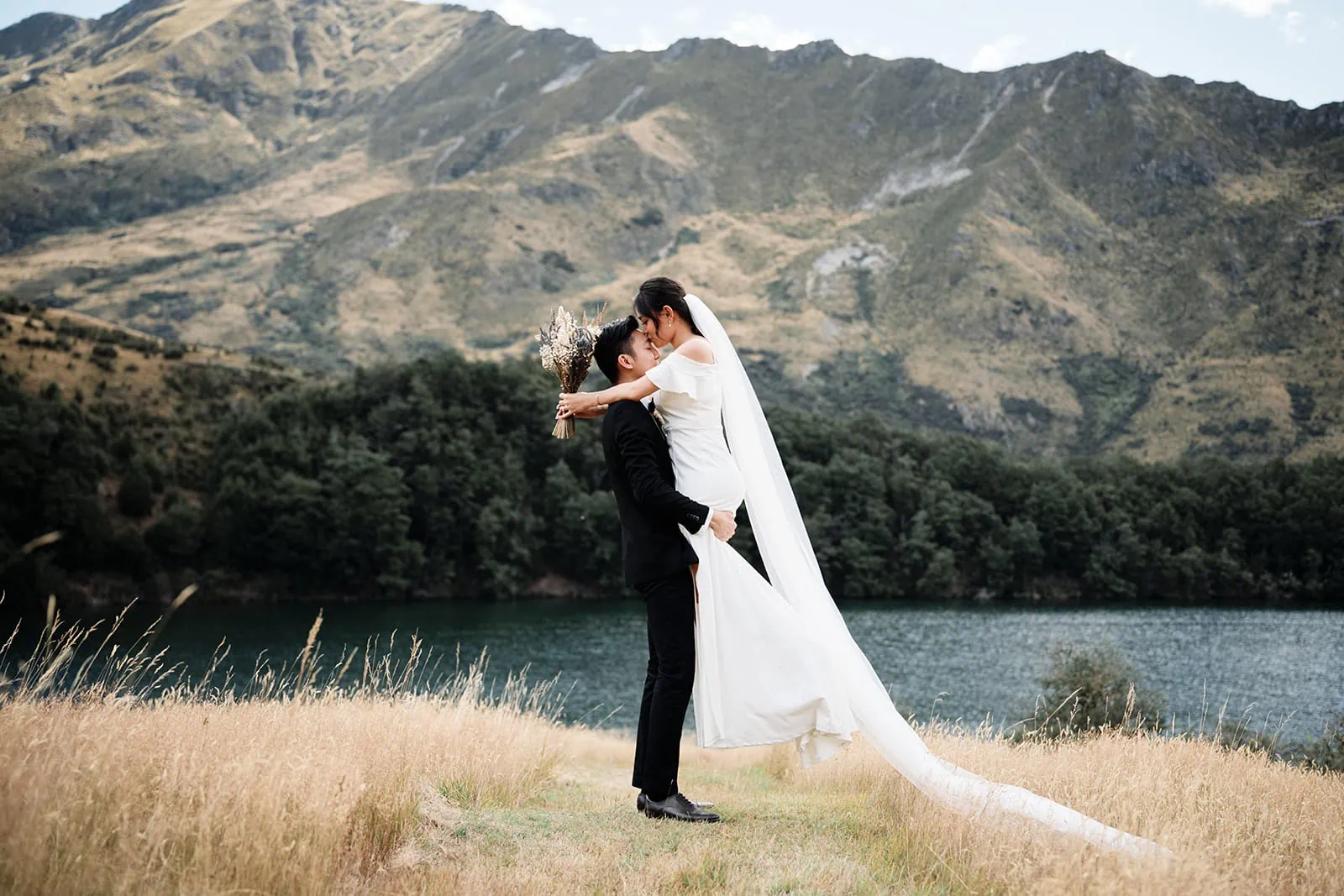 A pre-wedding photoshoot of Dios and Carlyn at Cecil Peak, Queenstown, with a breathtaking lake backdrop.