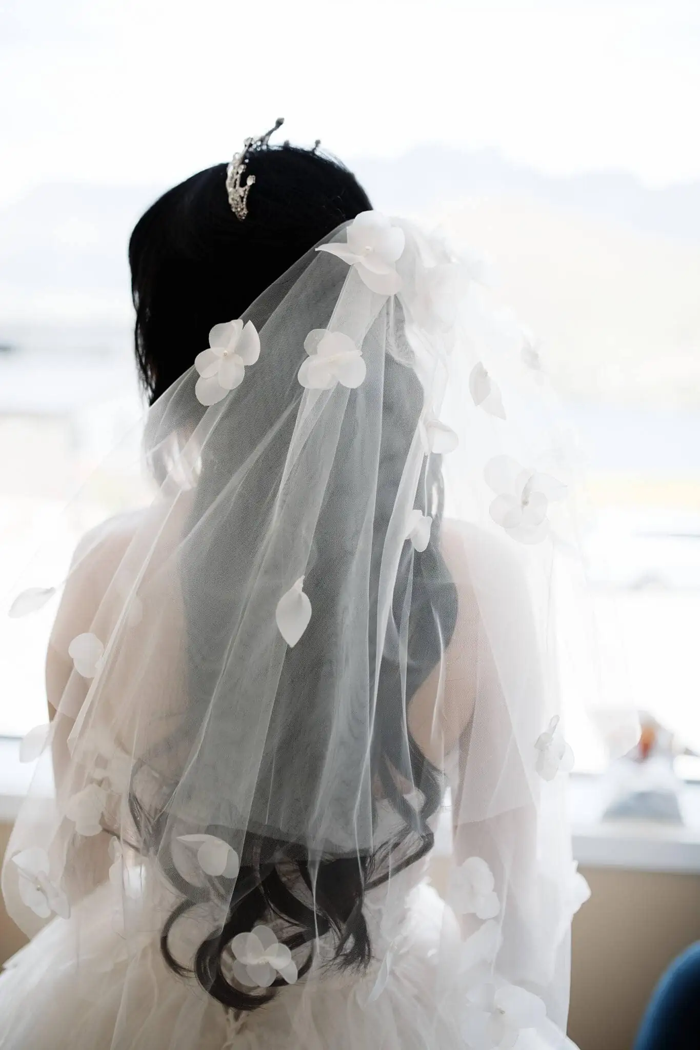 Intimate bride with veil in front of window during Carlos and Wanzhu's Cecil Peak Heli Elopement Wedding.