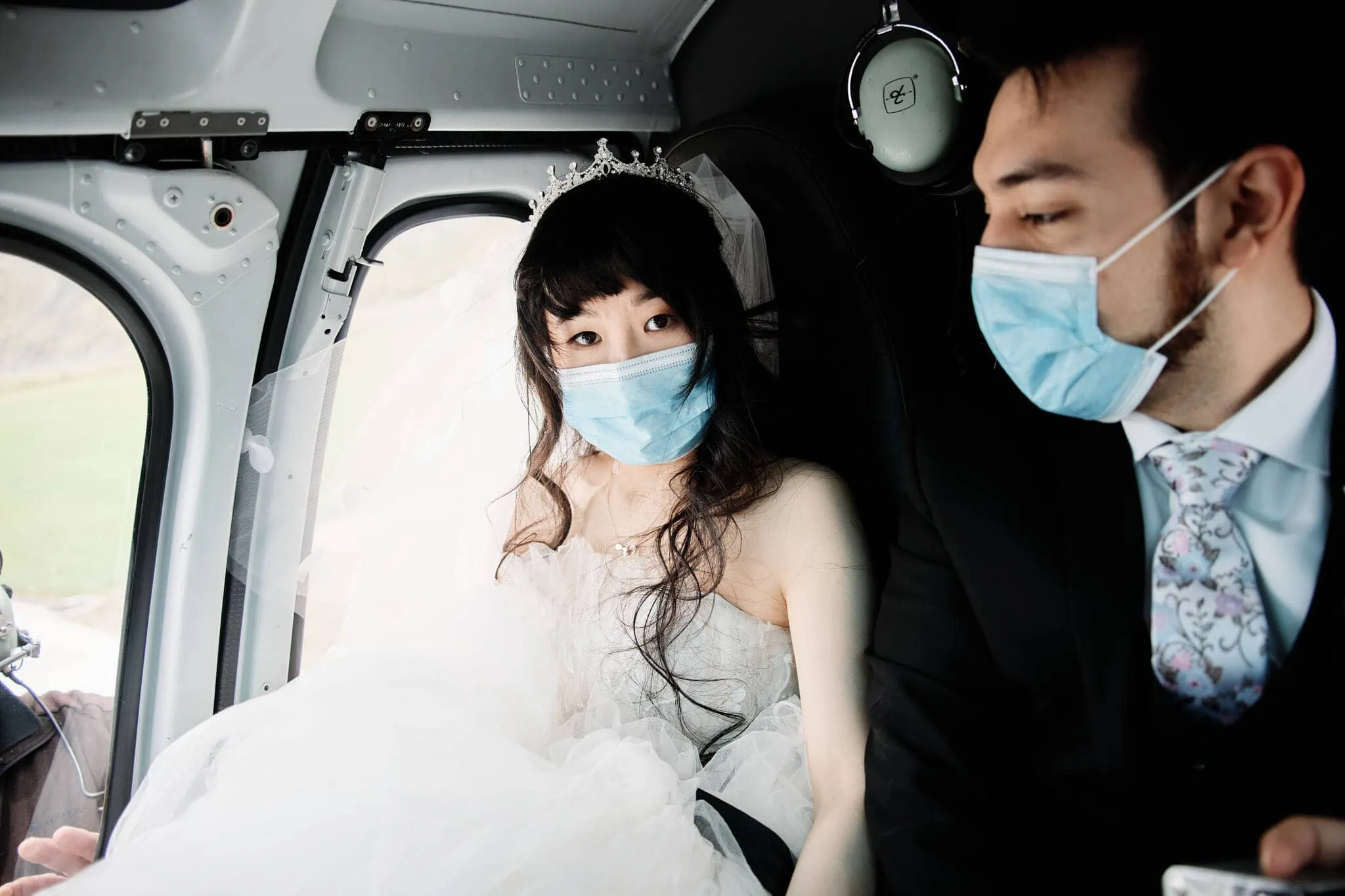 Carlos and Wanzhu have an intimate Cecil Peak Heli elopement wedding, wearing surgical masks in a helicopter.