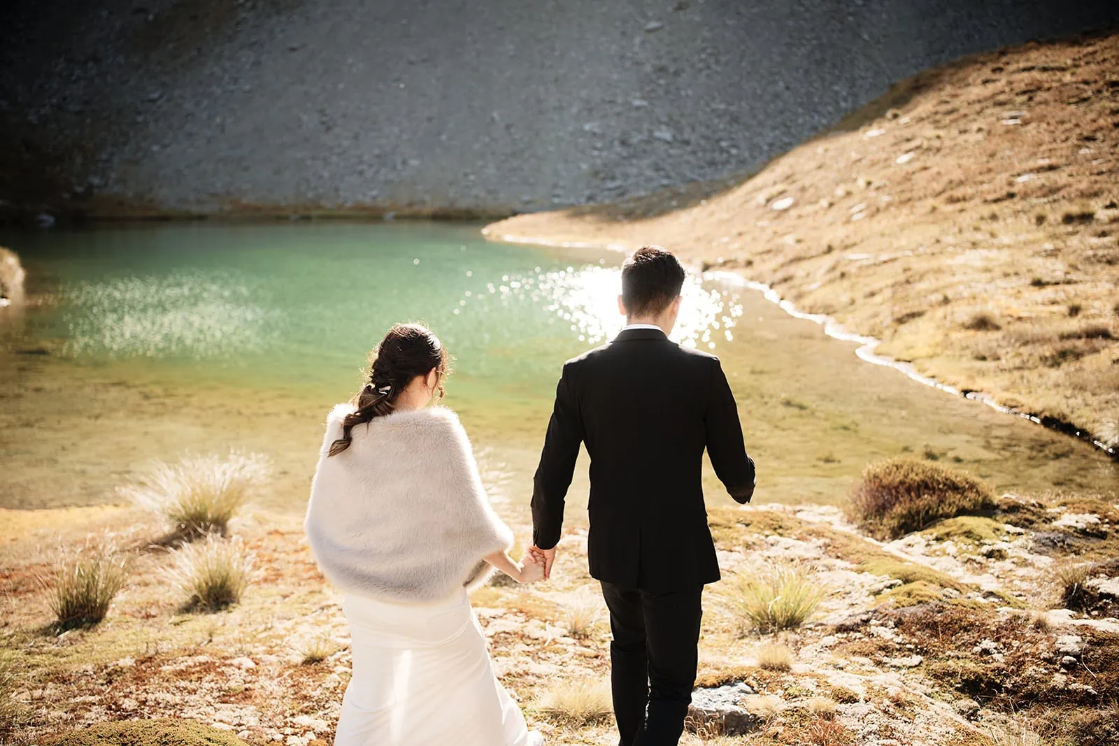 Dios & Carlyn's Queenstown Heli Pre Wedding at Cecil Peak - a couple holding hands in front of a lake.