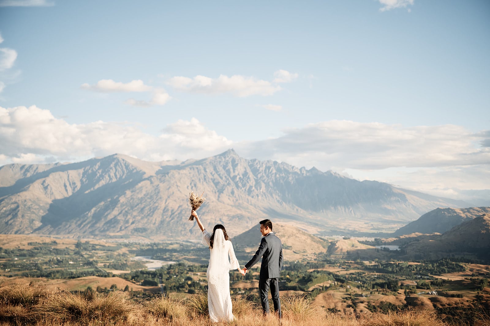 Dios & Carlyn on top of Cecil Peak, a hill with mountains in Queenstown for their Heli Pre Wedding photoshoot.