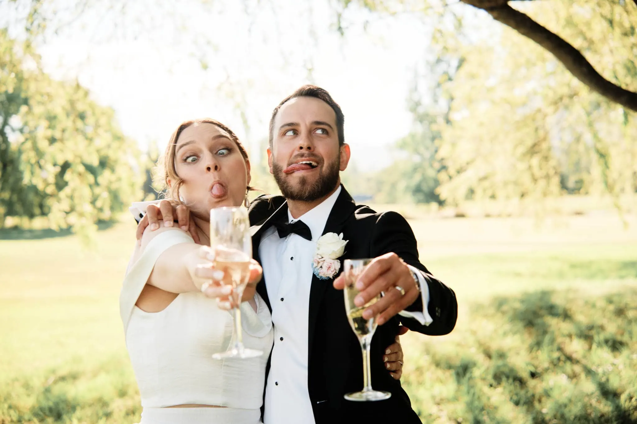 Sapphire and JJ's Queenstown Heli Elopement Wedding - A bride and groom toasting with champagne glasses in a field.