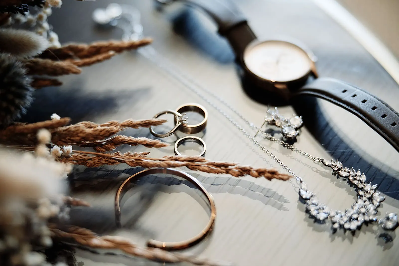 A collection of jewelry and watches on a table, featuring Dios & Carlyn.