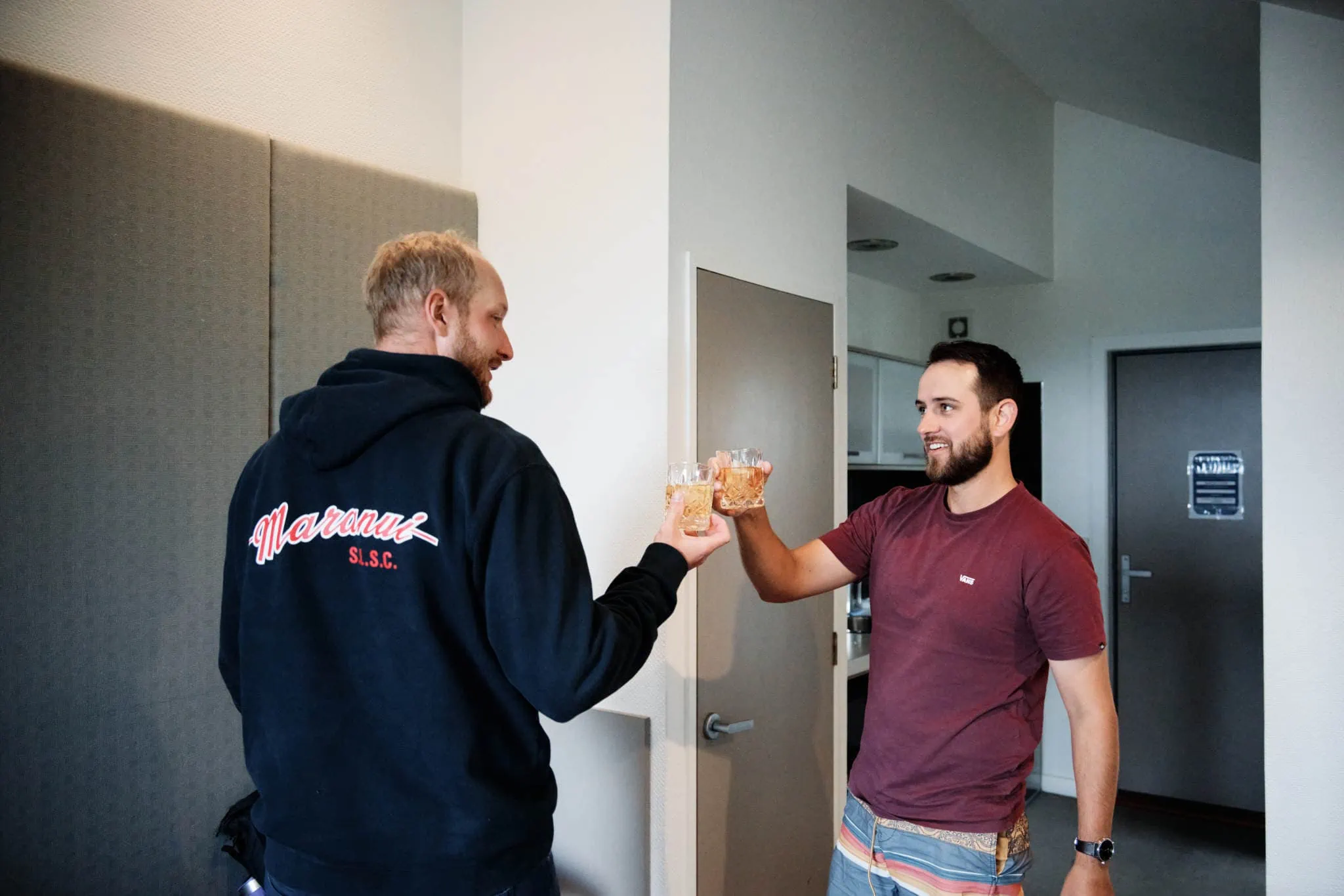 Sapphire and JJ's Queenstown Heli Elopement Wedding captures two men standing next to each other in a room.