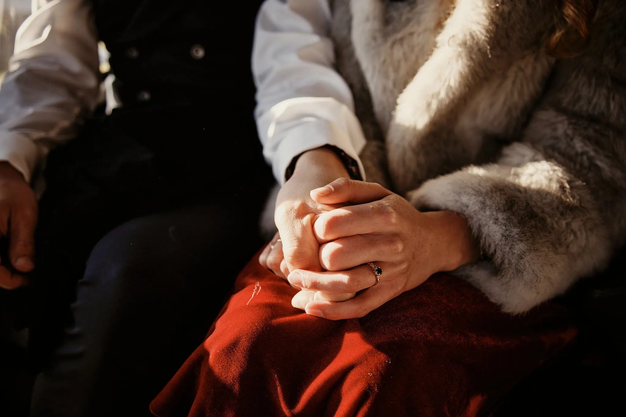 Claire and Rob, holding hands on a train during their Heli Elopement Wedding at Cecil Peak.