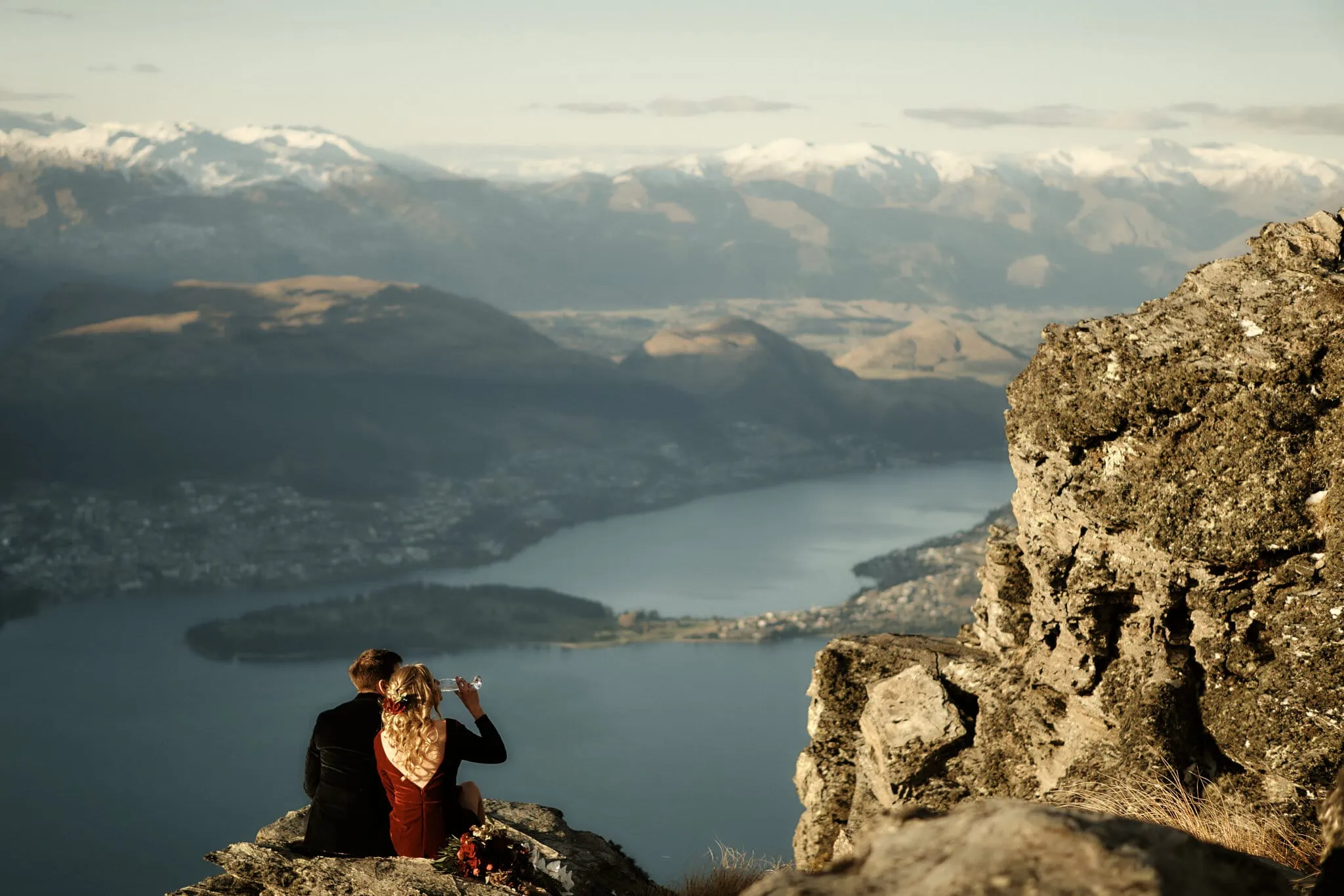 One-sentence description: Claire and Rob celebrate their heli elopement wedding at Cecil Peak, sitting on top of a mountain overlooking Lake Wanaka.
