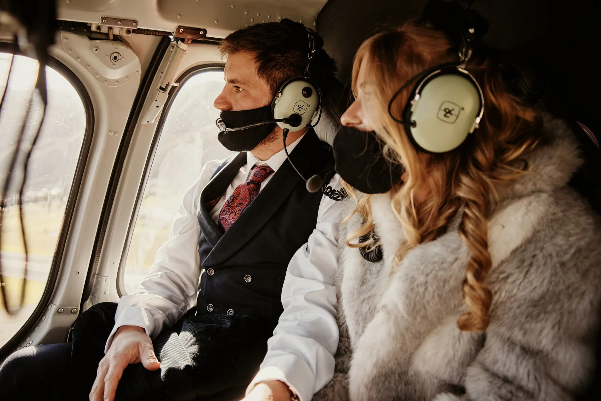 Claire and Rob exchange vows in a helicopter during their Heli Elopement Wedding at Cecil Peak, while donning face masks.