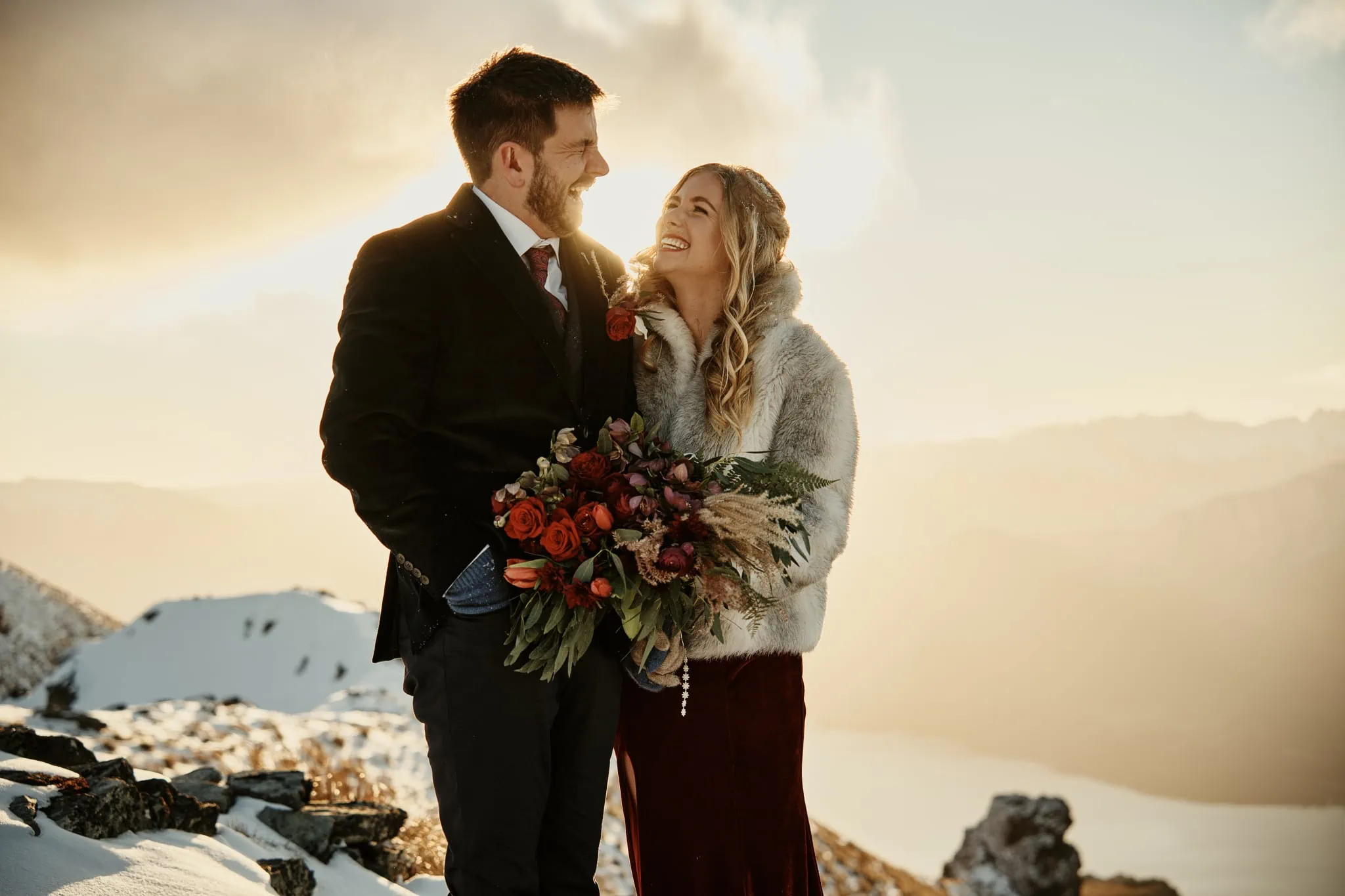 Claire and Rob's heli elopement wedding at Cecil Peak, with the bride and groom standing on top of a snowy mountain.