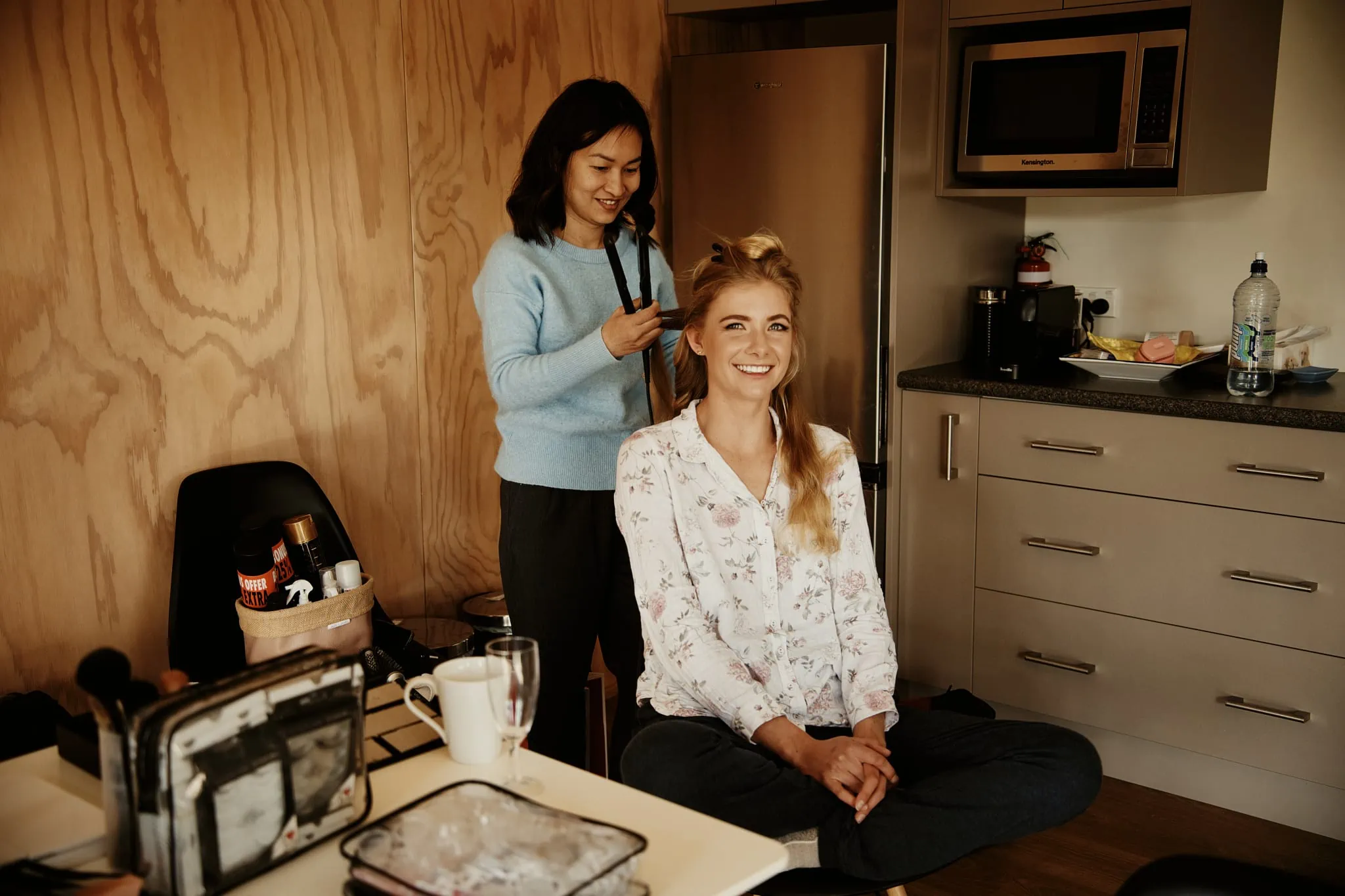 Claire is getting her hair done in a kitchen for her Heli Elopement Wedding at Cecil Peak.