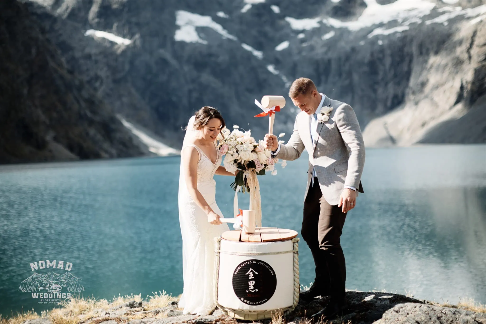 Enchanting Lake Erskine heli elopement wedding with Amy and Eden standing in front of a lake with mountains in the background.
