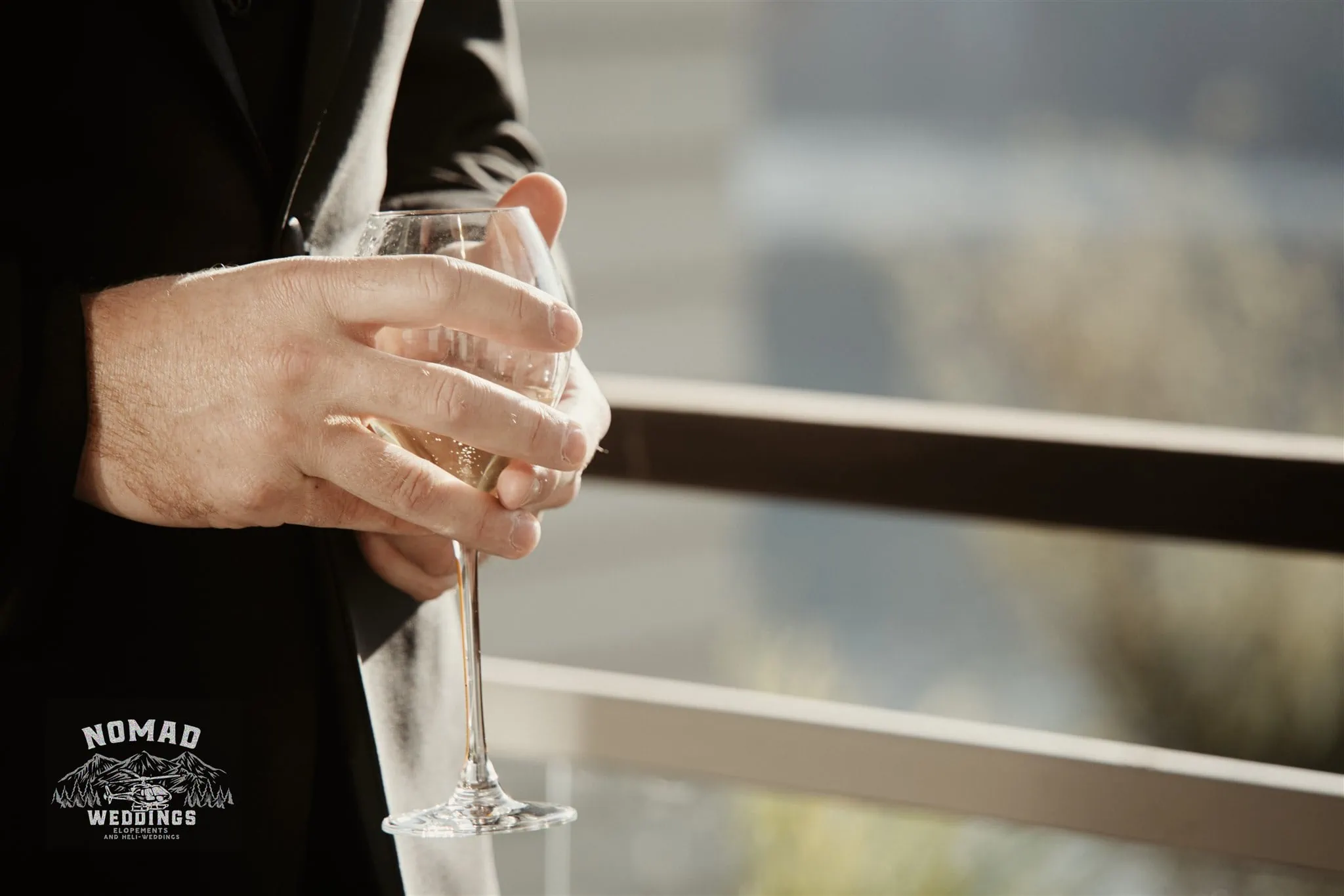A man holding a glass of wine at a Coromandel Peak Heli Elopement Wedding.