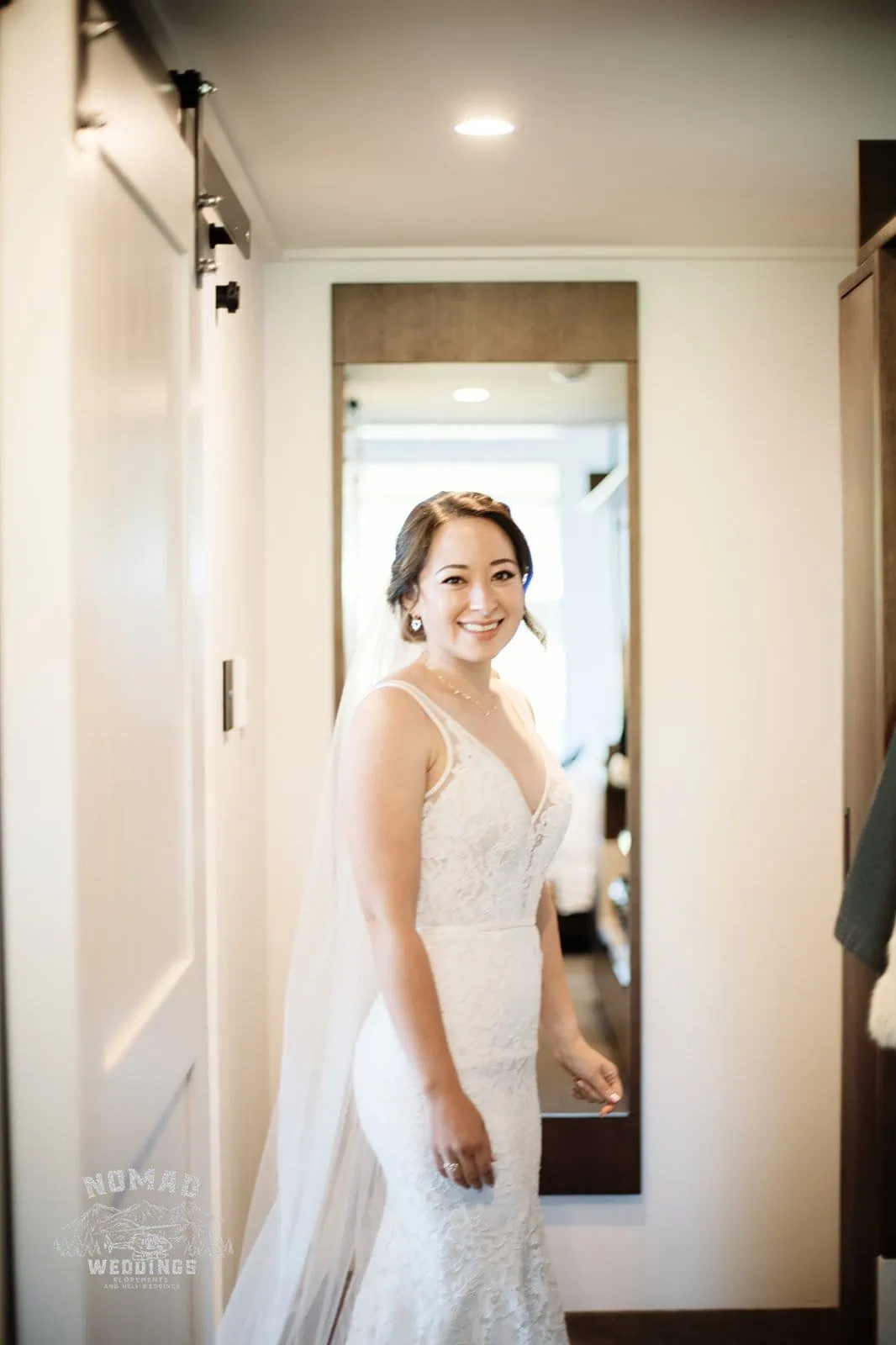 Amy & Eden's enchanting wedding ceremony takes place at Lake Erskine with the bride in her beautiful wedding dress, captured in front of a mirror.