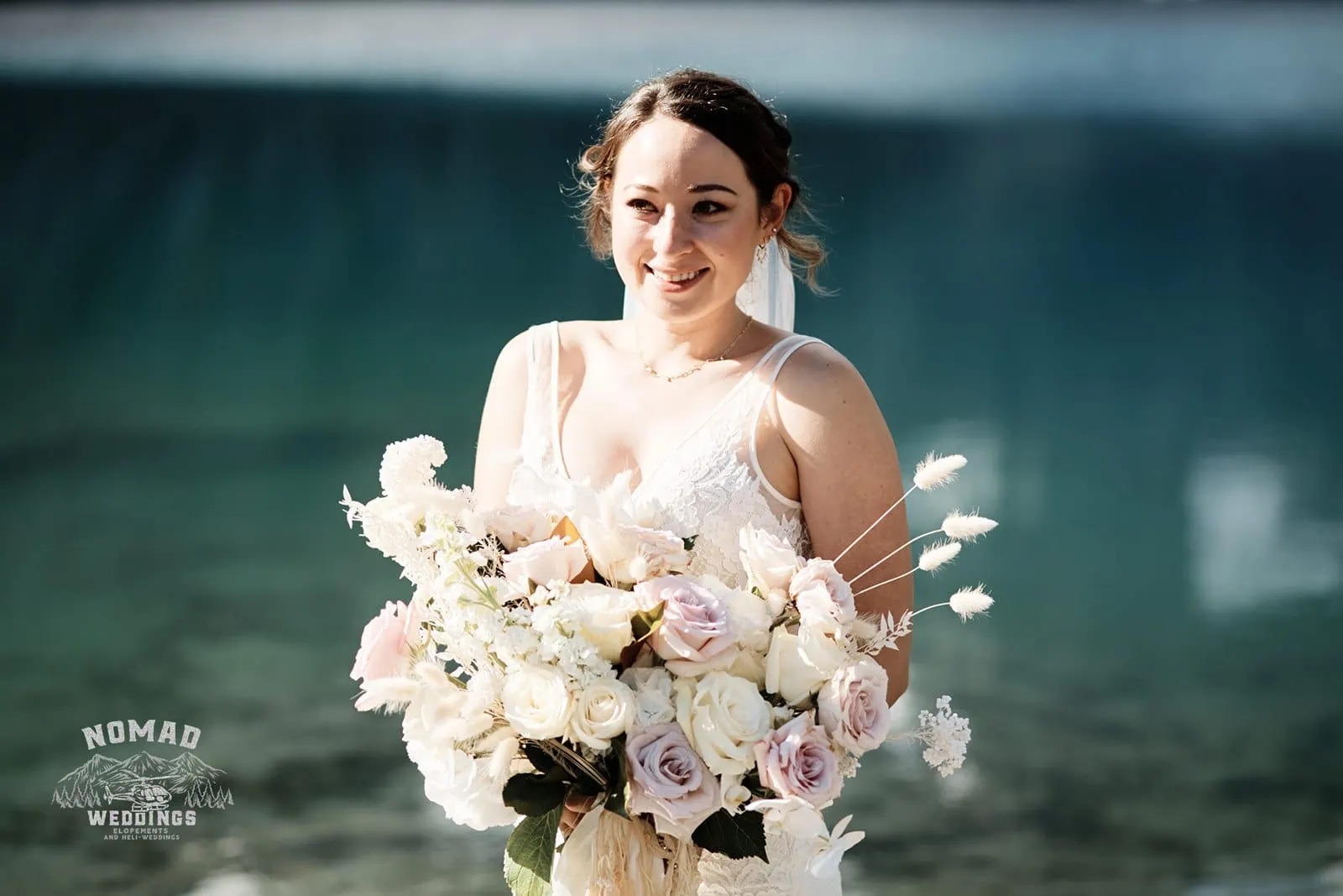 Amy holding a bouquet in front of Enchanting Lake Erskine.
