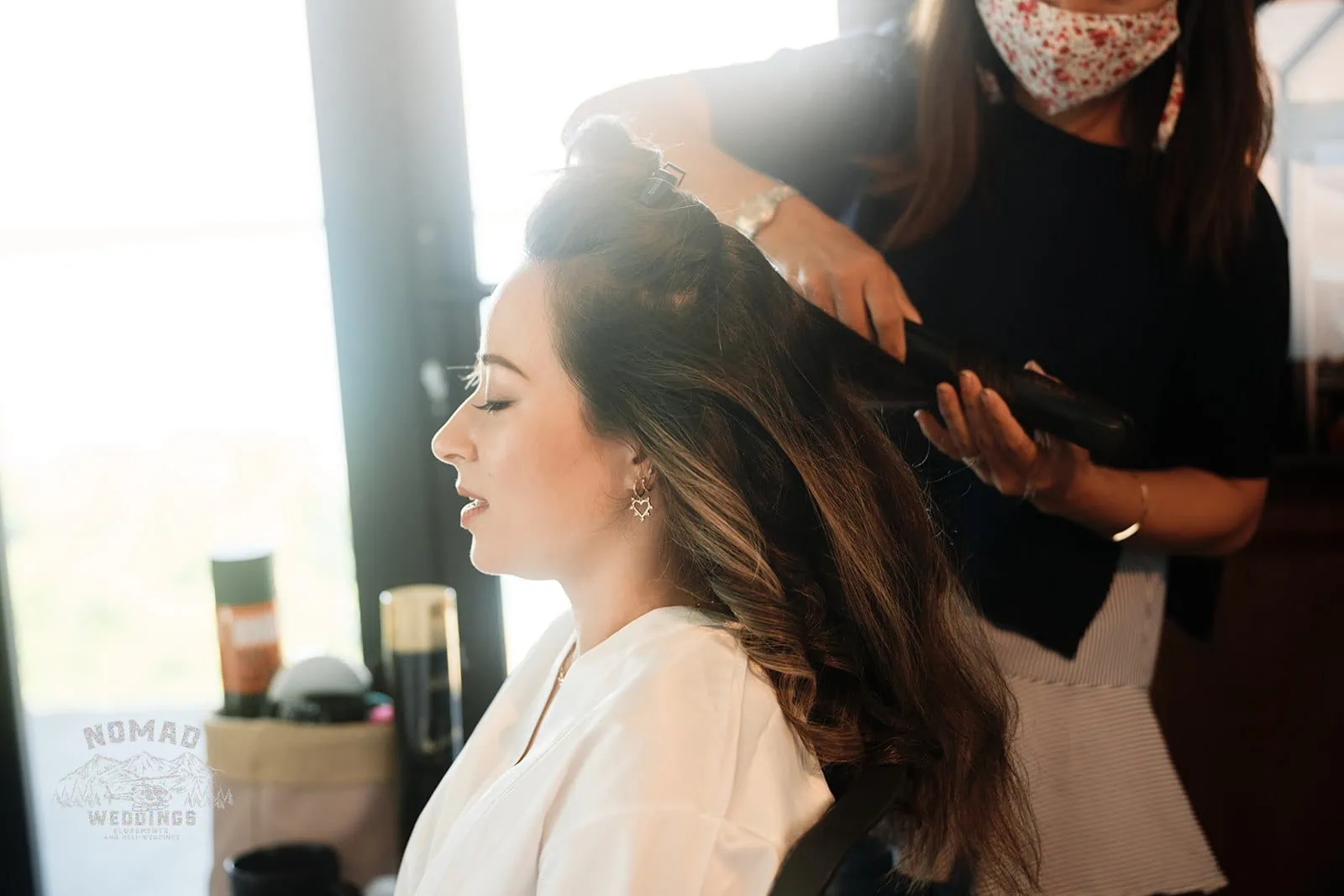A woman getting her hair done for an enchanting elopement wedding.