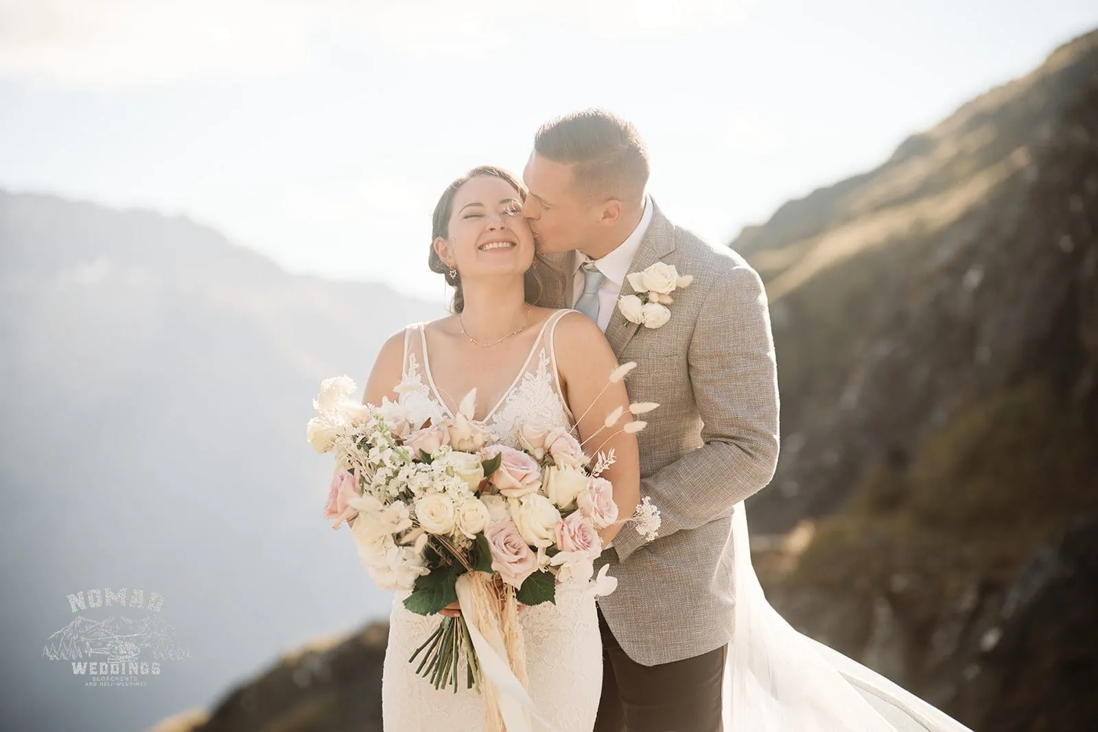 Amy and Eden share an enchanting kiss on the edge of a mountain during their heli elopement wedding in New Zealand.