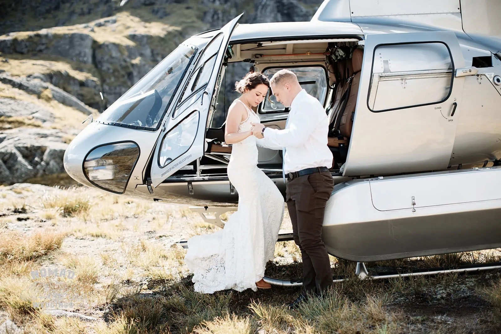 Amy and Eden's enchanting Lake Erskine heli elopement wedding captures a stunning moment beside a helicopter.
