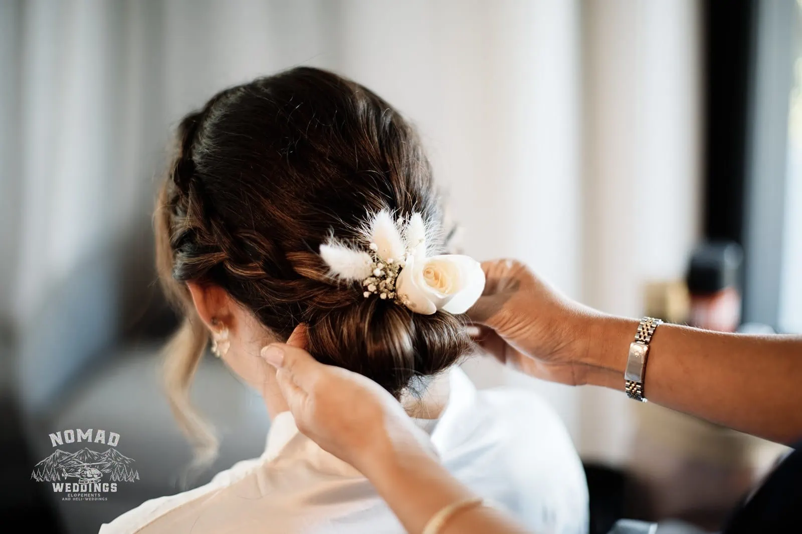 Amy, a bride, getting her hair done with a flower in her hair for her enchanting Lake Erskine heli elopement wedding with Eden.