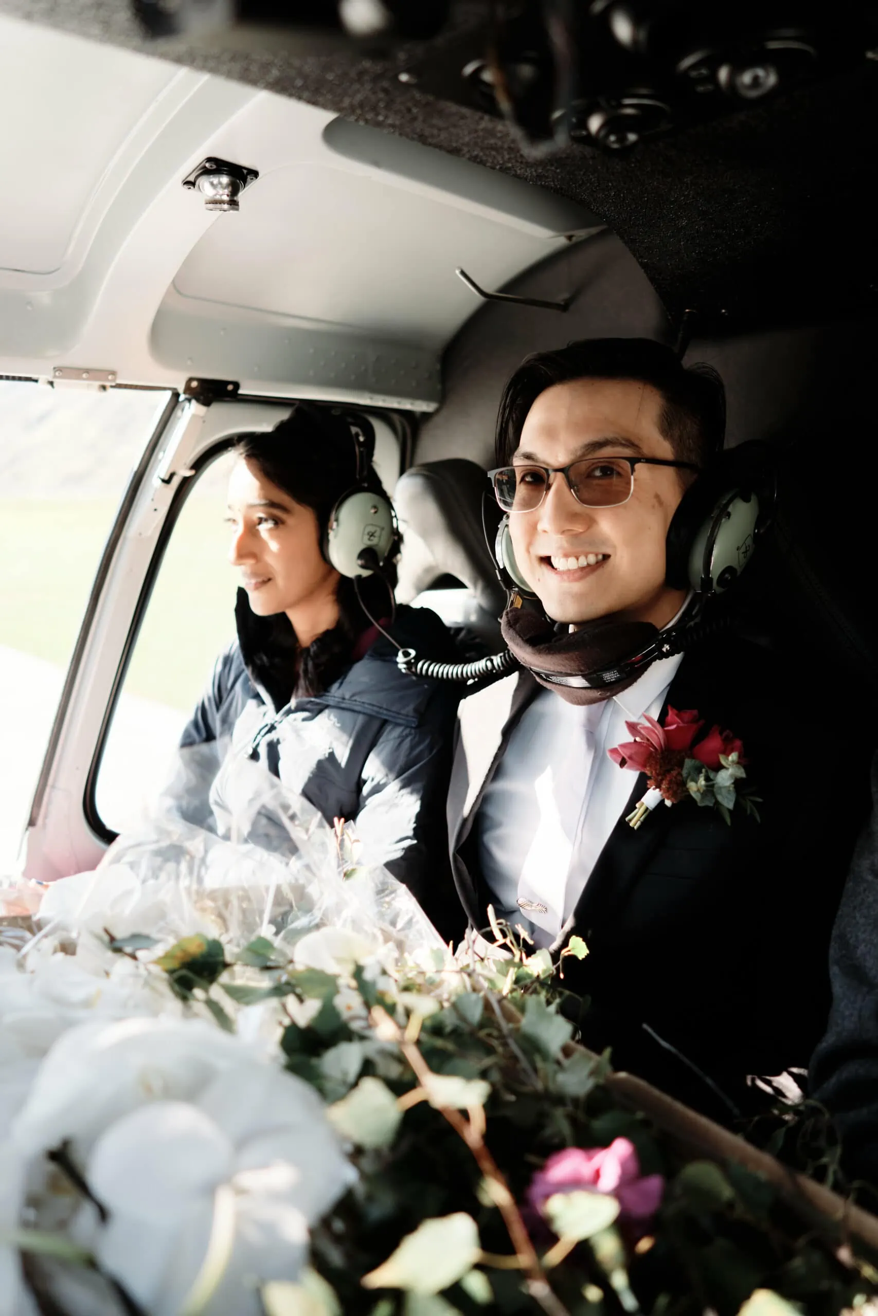 A bride and groom sitting in a helicopter.