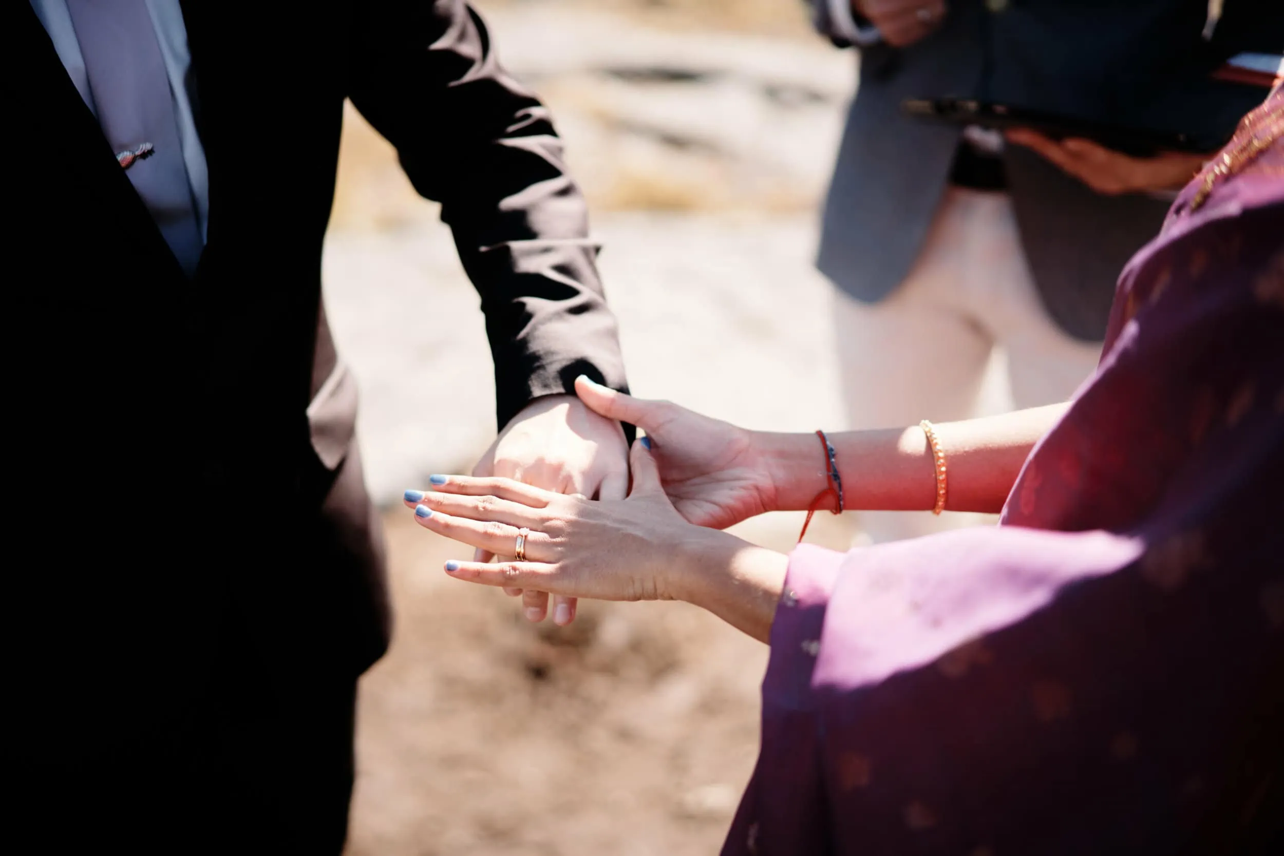A man is putting a ring on a woman's hand.