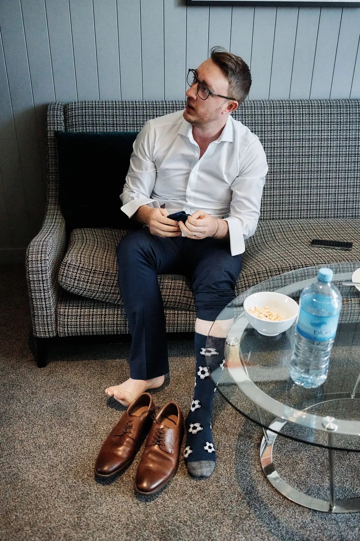 A man named Ace sitting on a couch with a pair of socks.