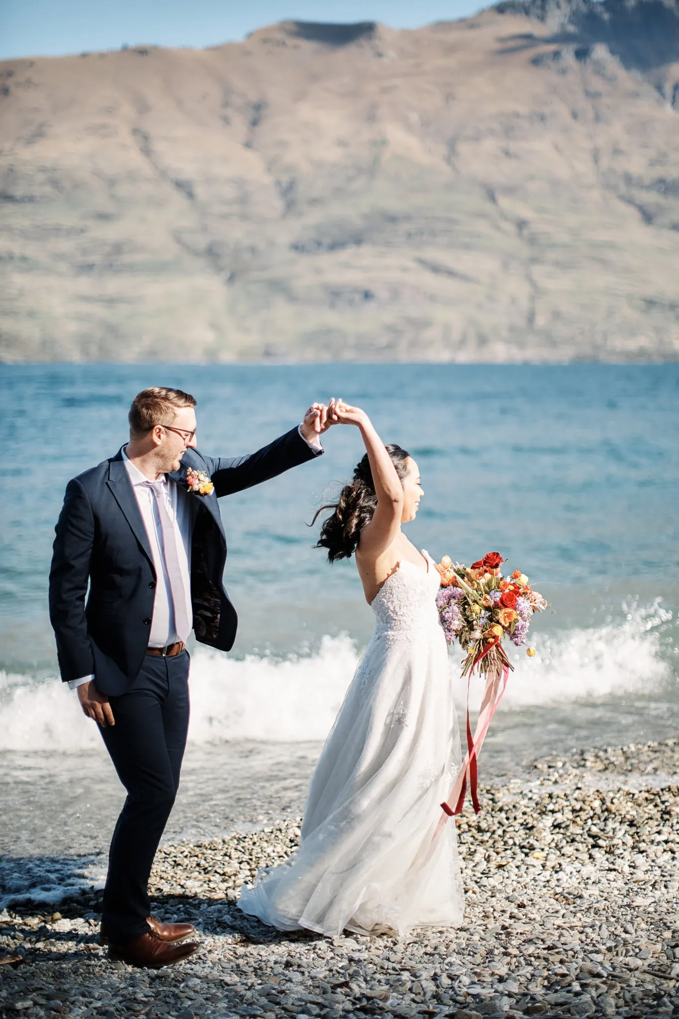 Ace and Alex dancing on the beach at Moke Lake for their pre-wedding shoot.
