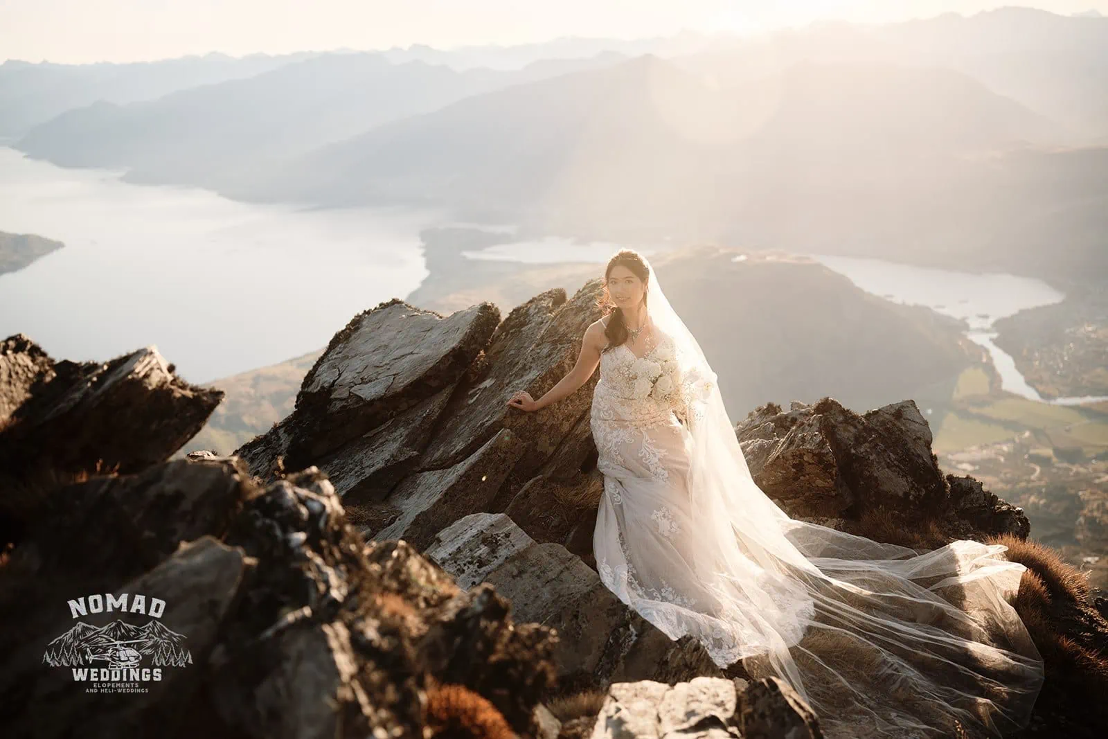 Connie and Andrew, a bride and groom, having their pre-wedding shoot on top of The Remarkables mountain overlooking Lake Wanaka.