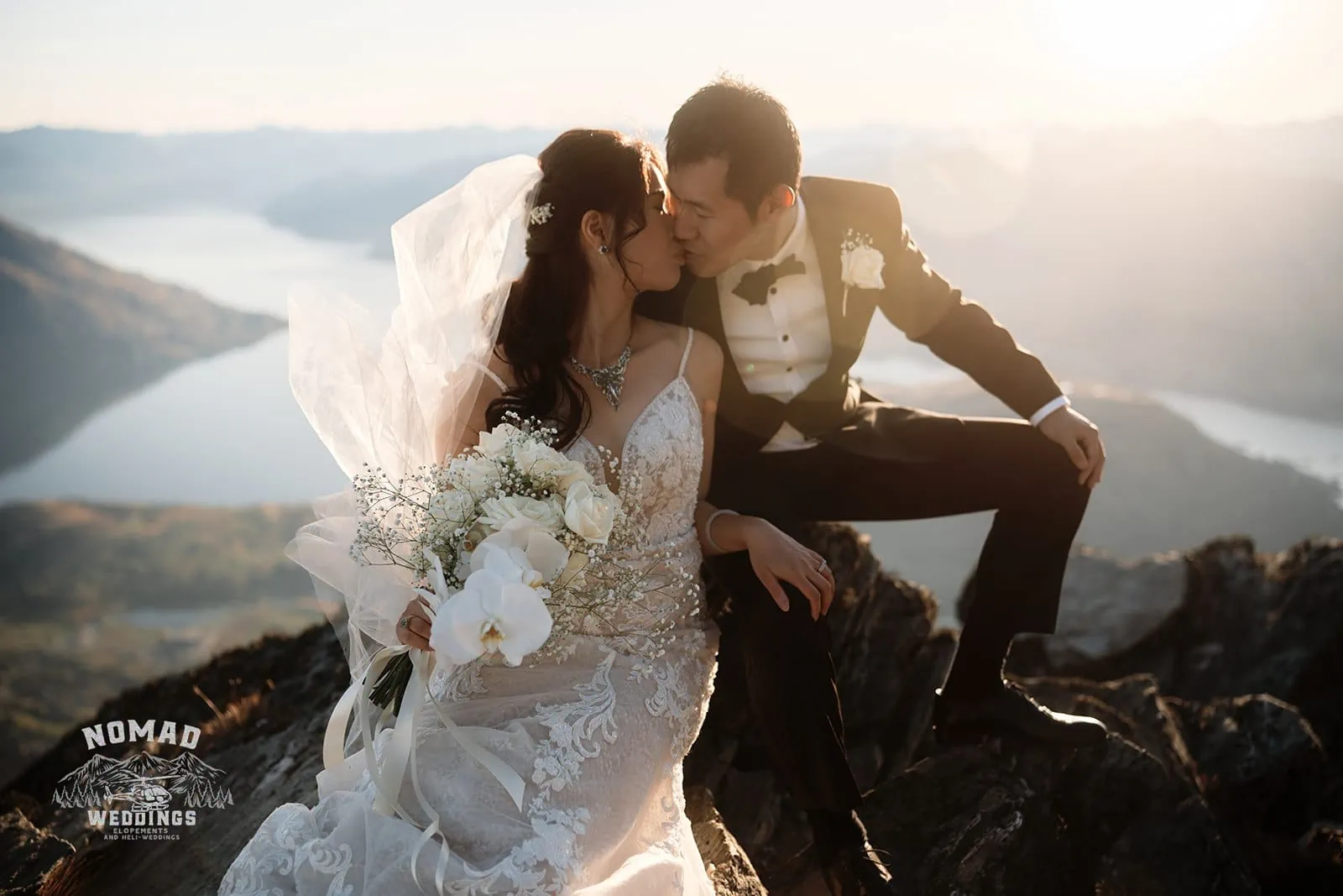 Connie and Andrew share a romantic kiss during their pre-wedding shoot atop The Remarkables mountain at sunset.
