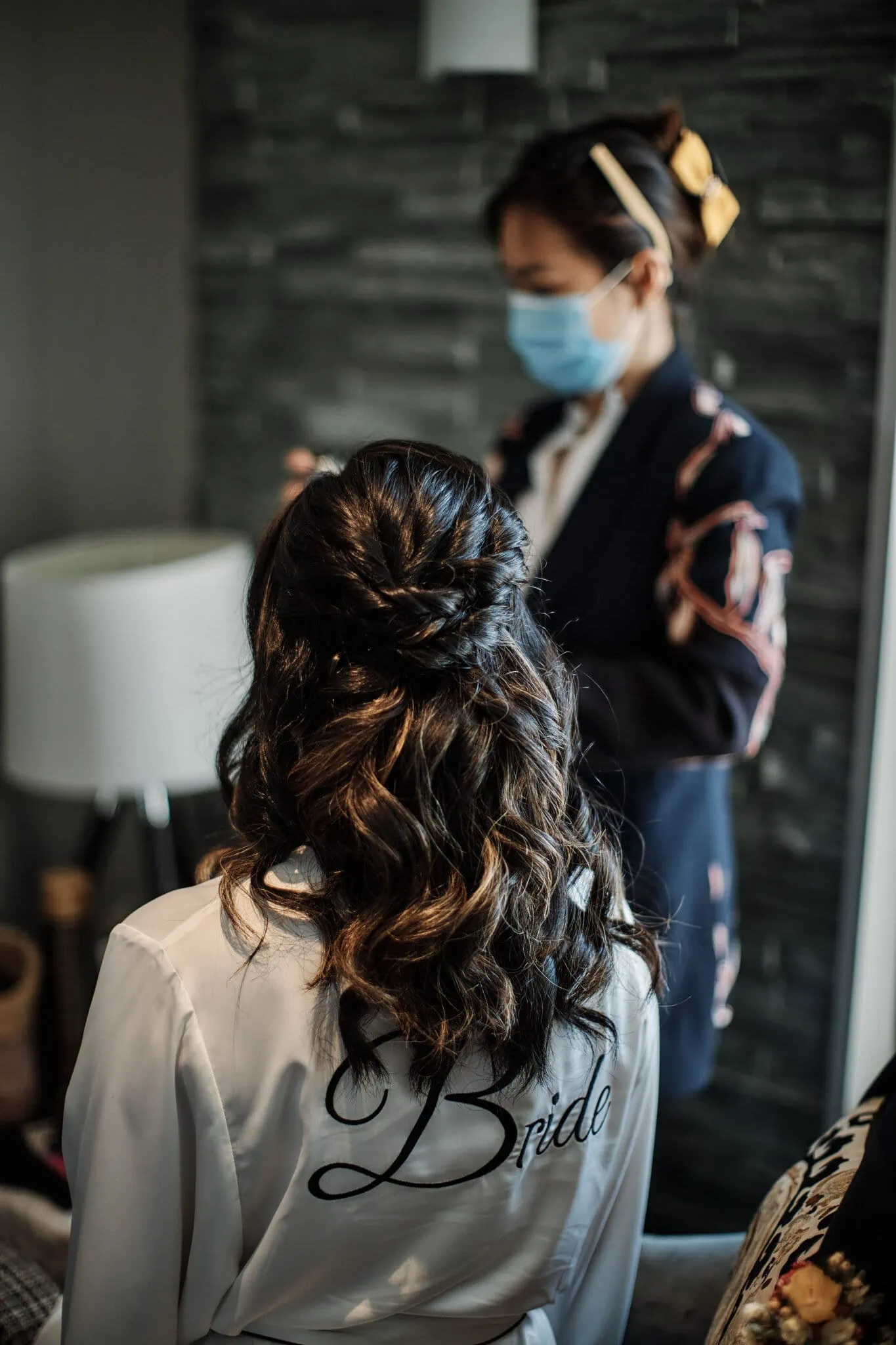 A bride, Ace, getting ready in a room with a face mask on for her Moke Lake Pre Wedding Shoot.