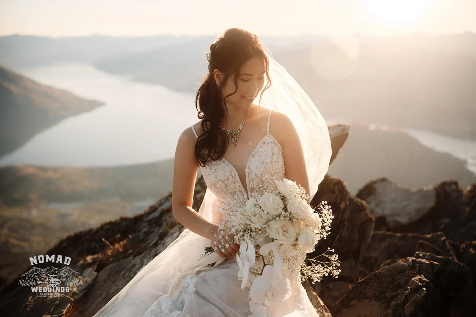Connie and Andrew's Remarkables Heli Pre Wedding Shoot featuring a bride on a mountain with her bouquet.