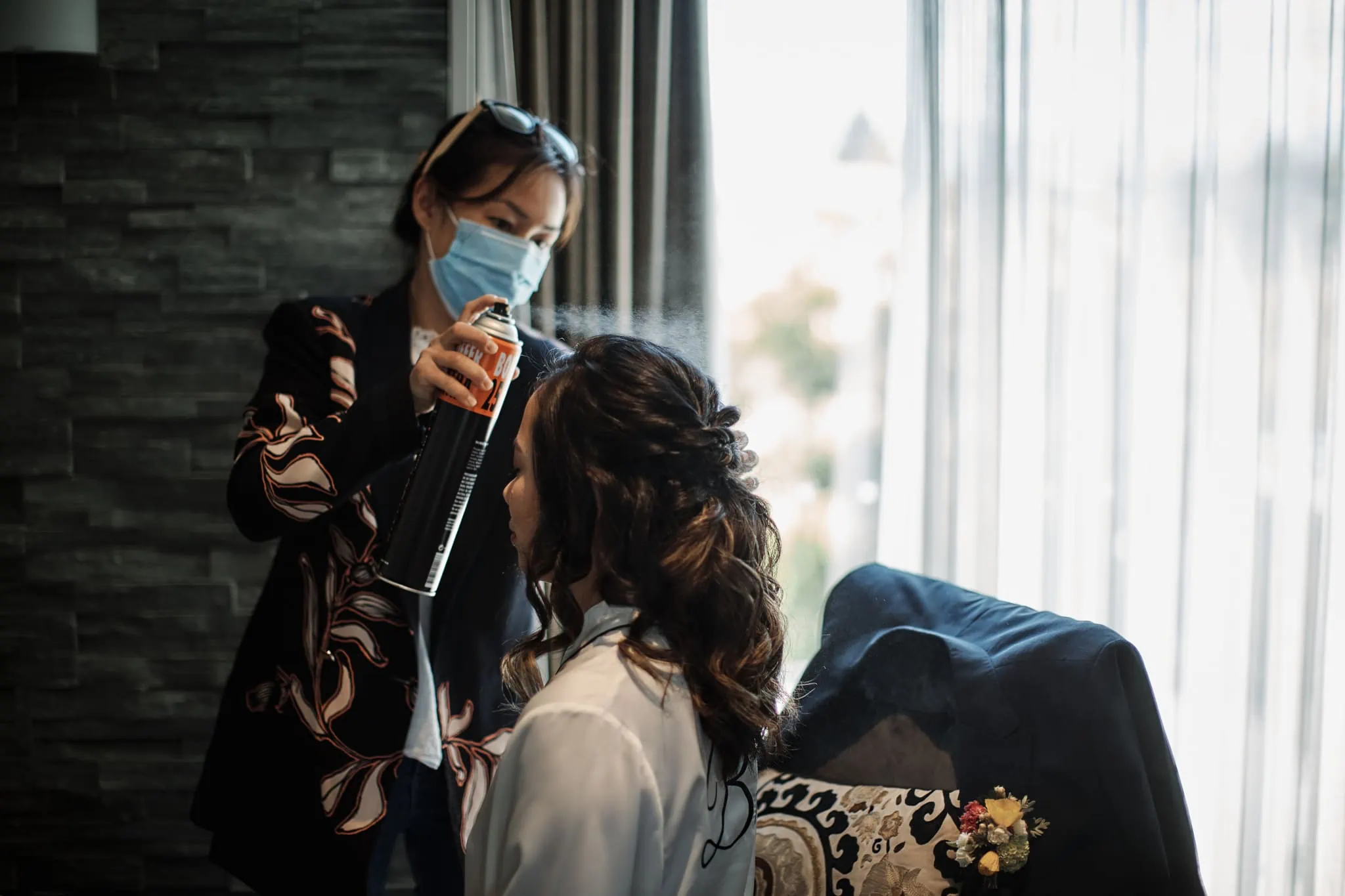 A woman wearing a face mask during a hair appointment.