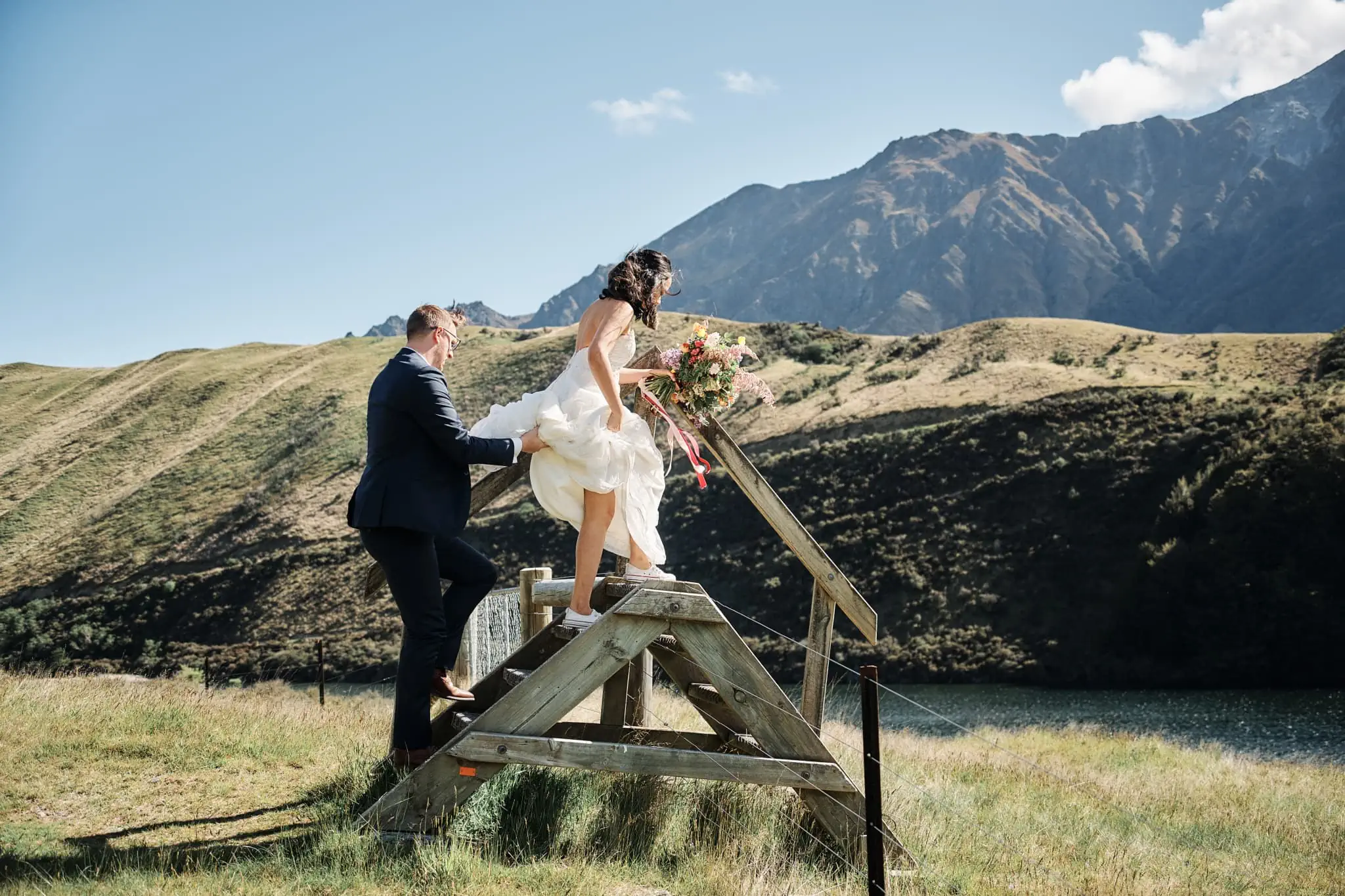 Ace and Alex's Moke Lake Pre Wedding Shoot features a bride and groom on a wooden platform against scenic mountains.
