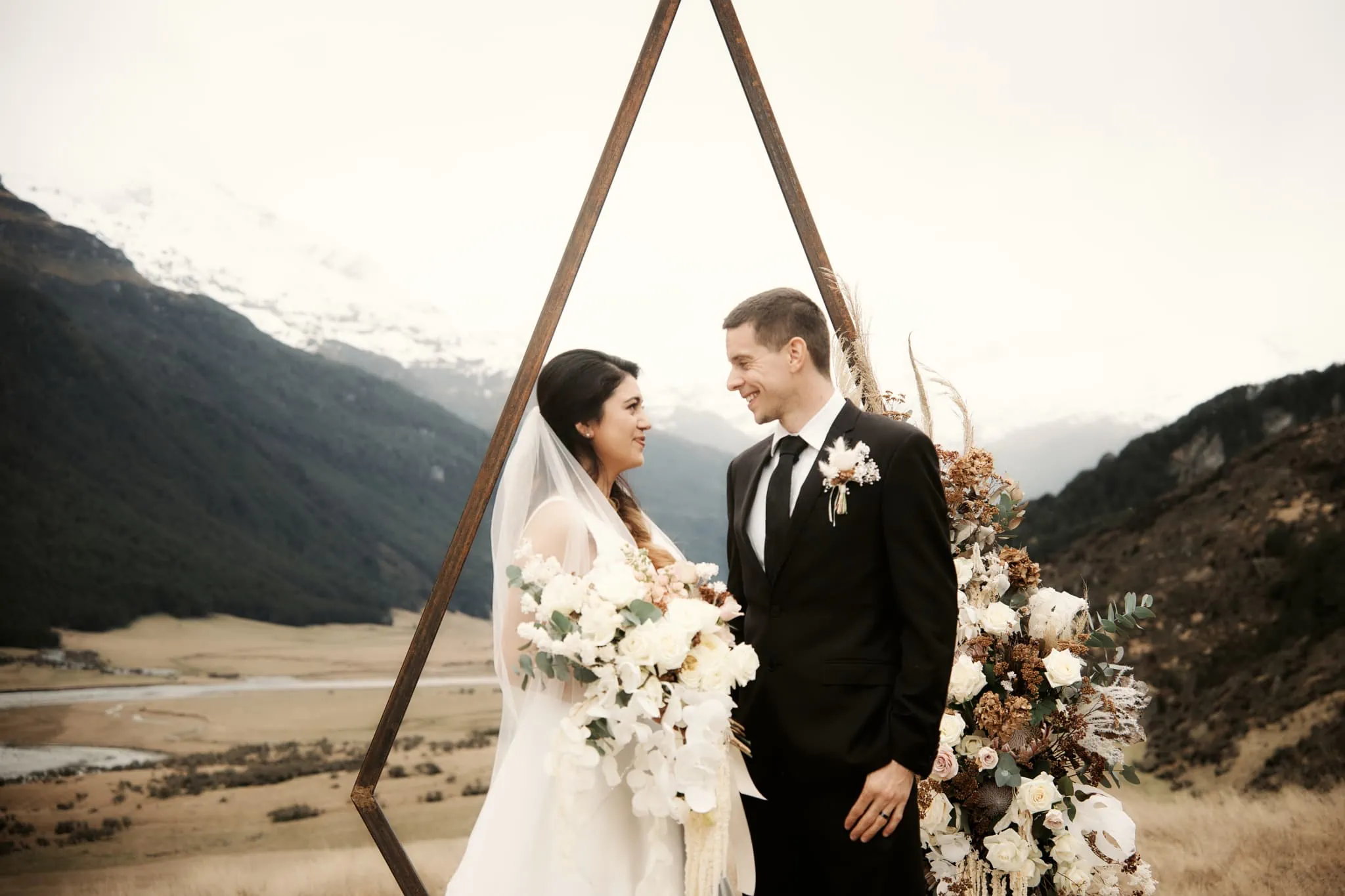 Michelle and Vedran at Rees Valley Station Elopement Wedding, standing in front of a geometric wedding arch.